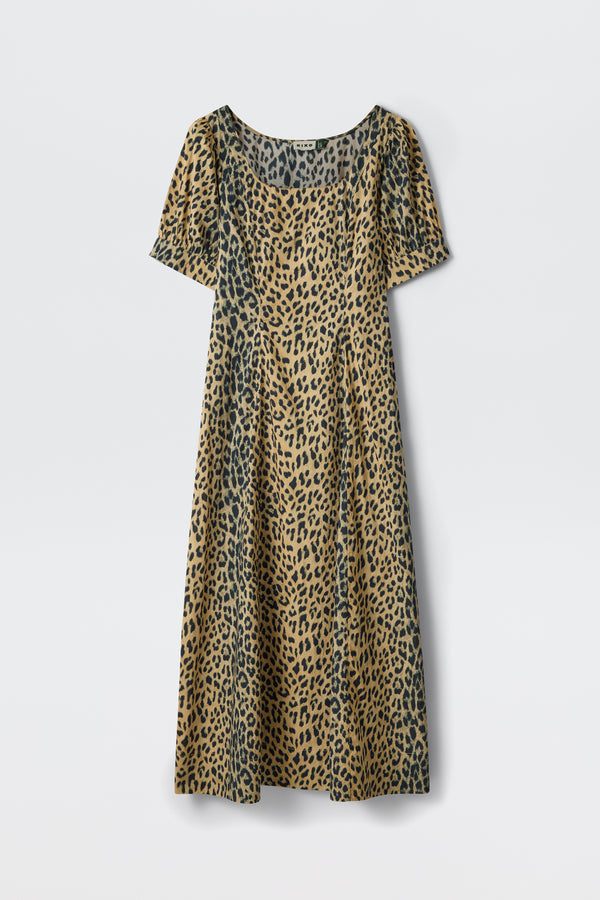 The Kathleen - Nina Leopard Brown is a short-sleeved, calf-length dress with a scoop neckline, featuring a tan and black leopard print, shown against a plain white background.