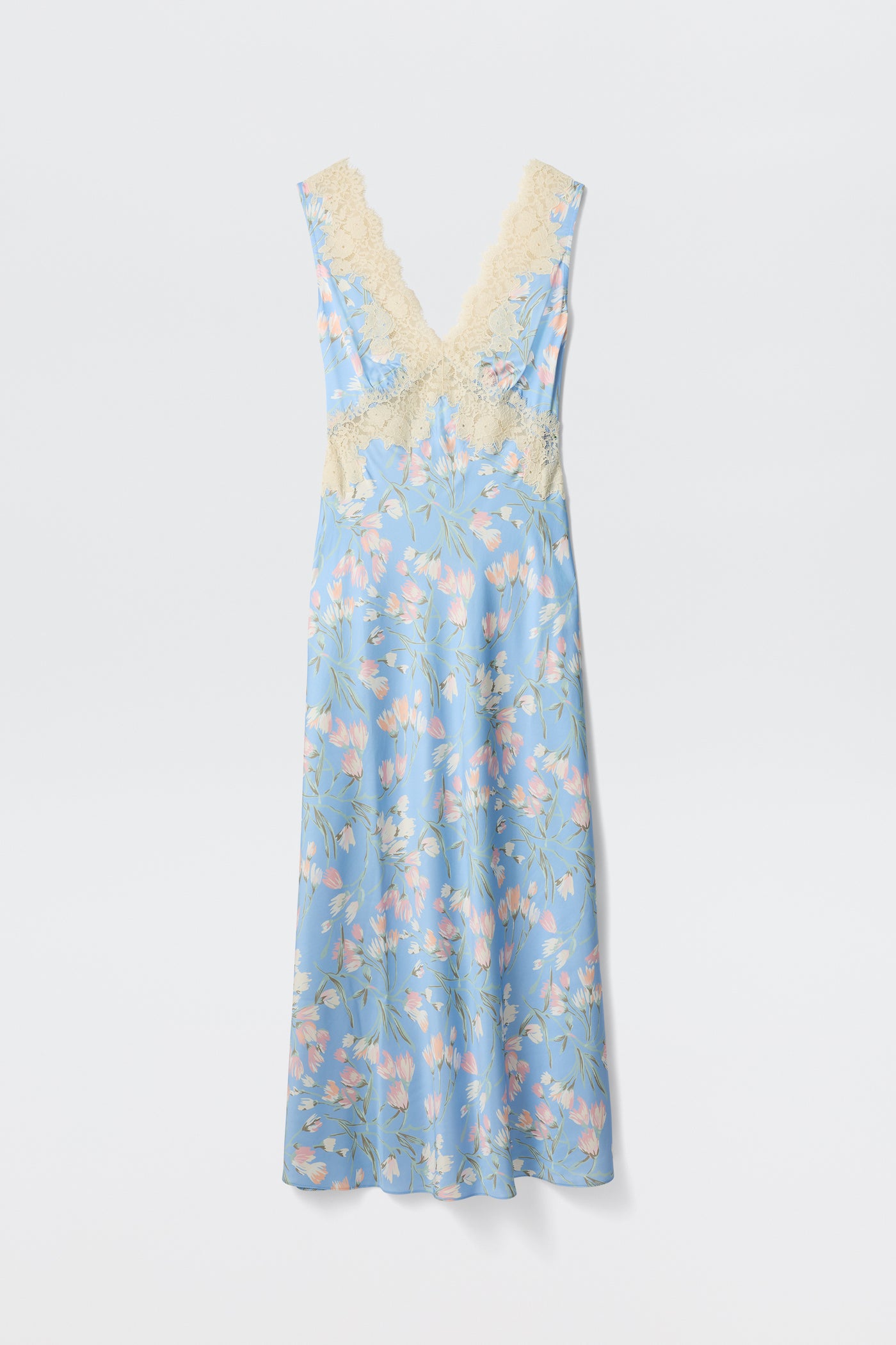 The Lysandra - Watercolour Floral Blue is a long, sleeveless dress featuring a light blue background with pink and white floral print and cream lace trim on the deep V-neck and waist, shown against a plain white backdrop.