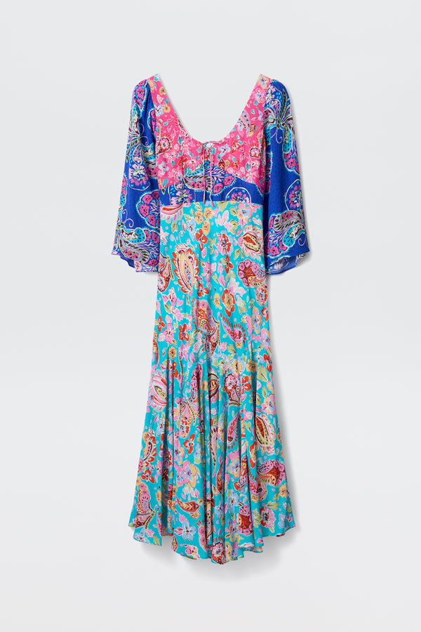 The Karly - Cara Mix Blue is an ankle-length dress with pink, blue, and turquoise paisley patterns, elbow-length sleeves, a fitted bodice, and flared skirt, shown on a plain white background.