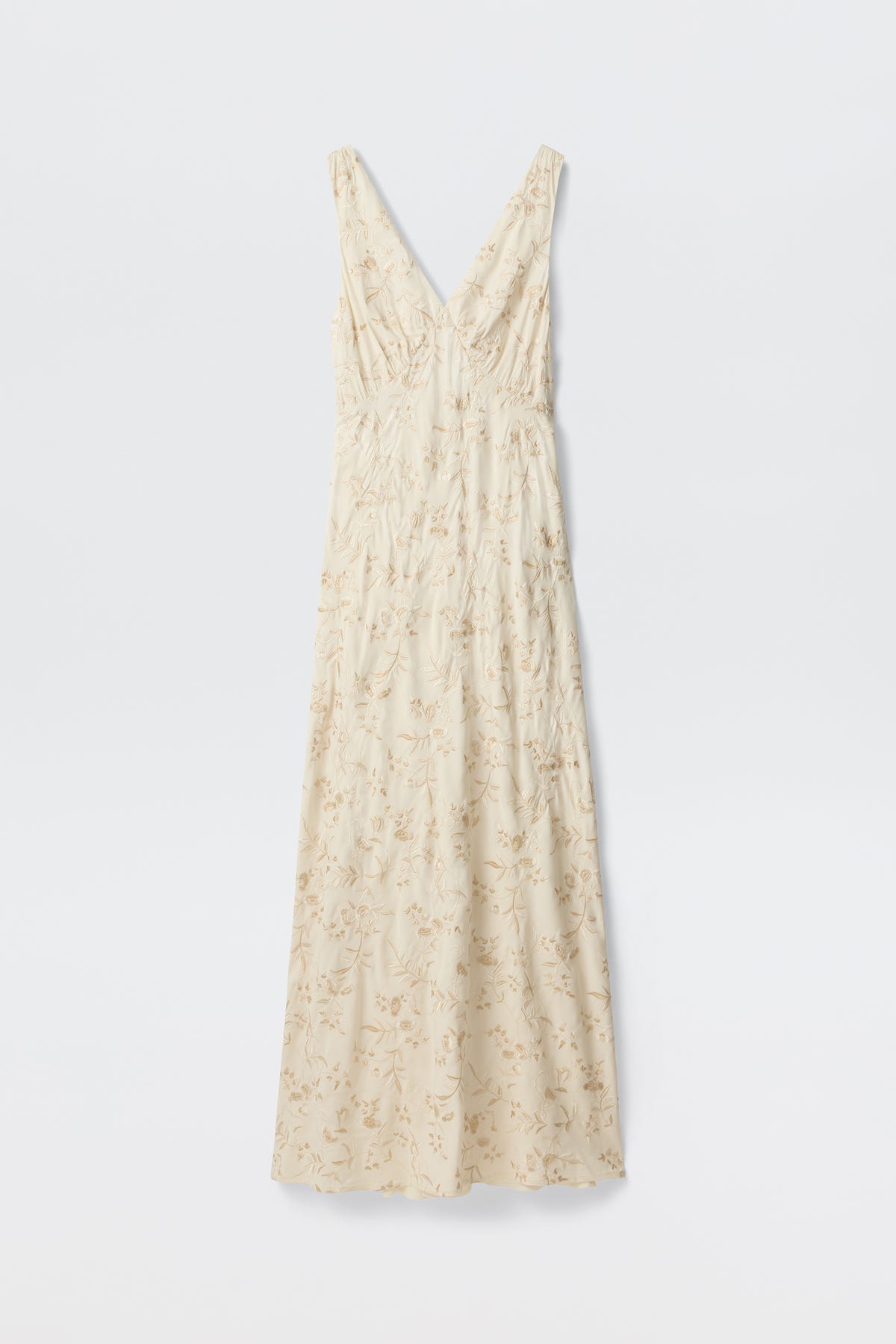 The Fawn - Botanical Embroidery Pearl is a sleeveless, cream maxi dress with a V-neckline, delicate light floral embroidery, and a form-fitted silhouette, displayed against a plain white background.