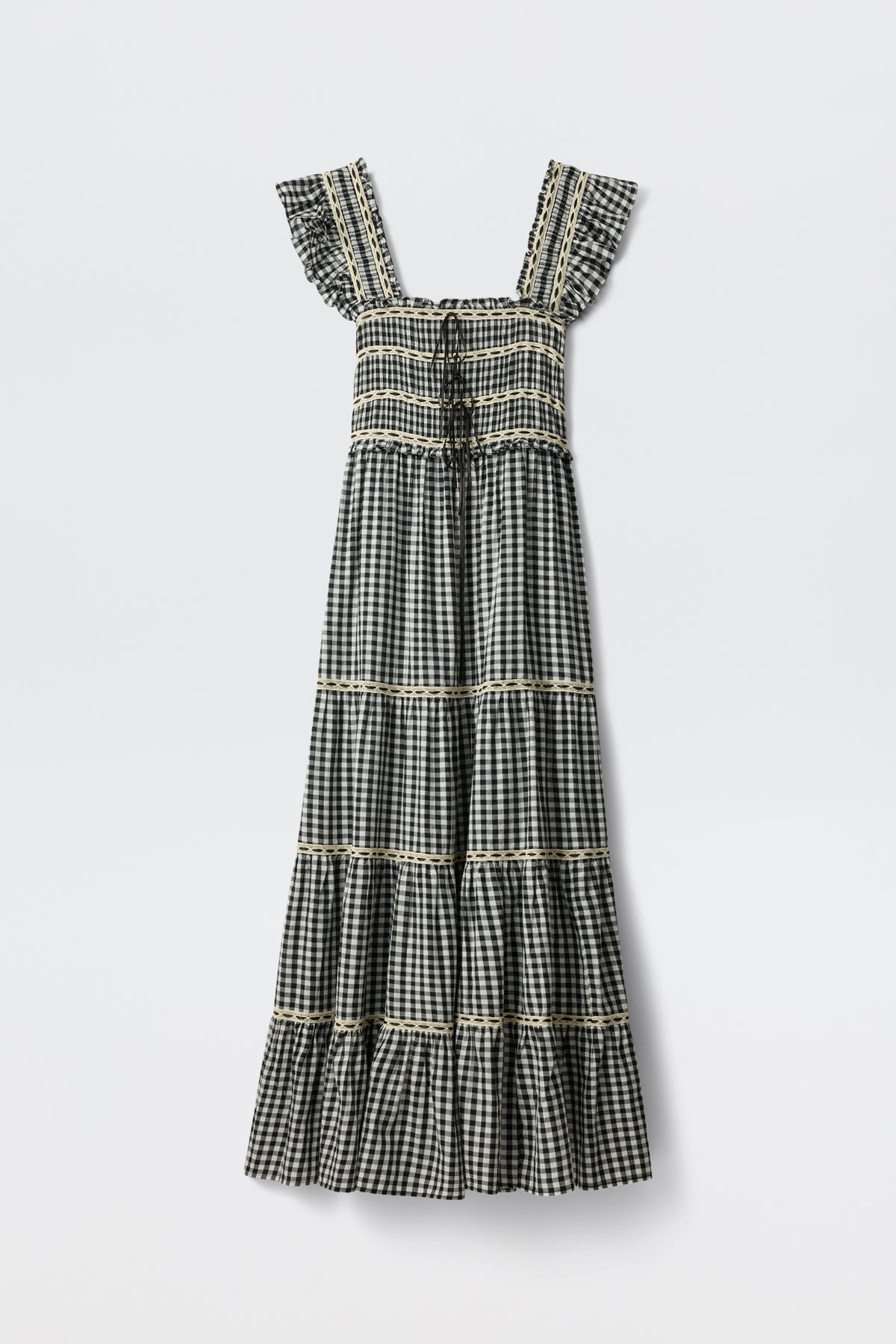 The Chandra - Beth Check Black is a sleeveless, ankle-length dress featuring a black and white gingham pattern, square neckline, ruffled straps, tiered skirt with lace trim on each tier, and vintage cottagecore style.