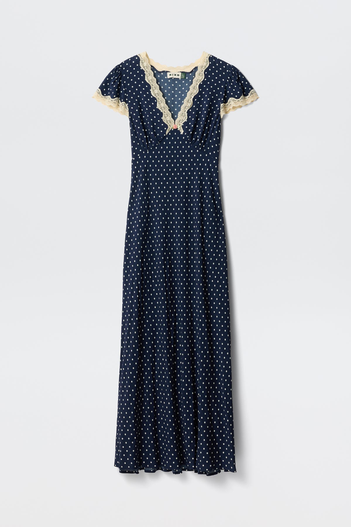 Clarice - Navy Polka Dot: A vintage-inspired, full-length rayon dress with white polka dots, short sleeves, and light beige lace trim on the V-neckline and sleeves, shown on a plain white background.