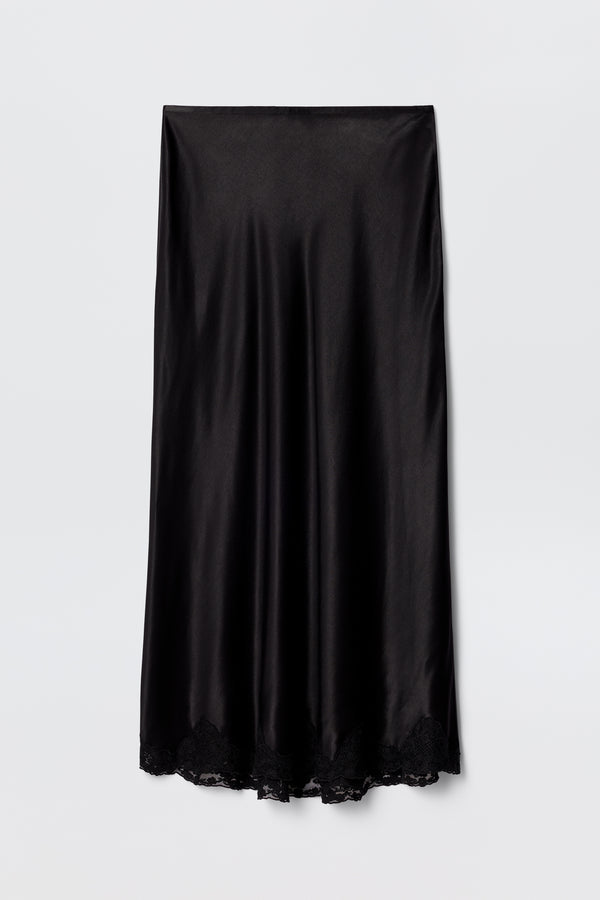 The Crystal - Black is a black satin bias-cut midi skirt with a slight sheen and delicate lace trim at the hem, displayed flat on a plain white background.