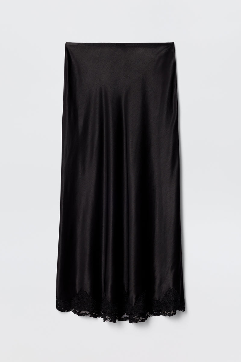 The Crystal - Black is a black satin bias-cut midi skirt with a slight sheen and delicate lace trim at the hem, displayed flat on a plain white background.