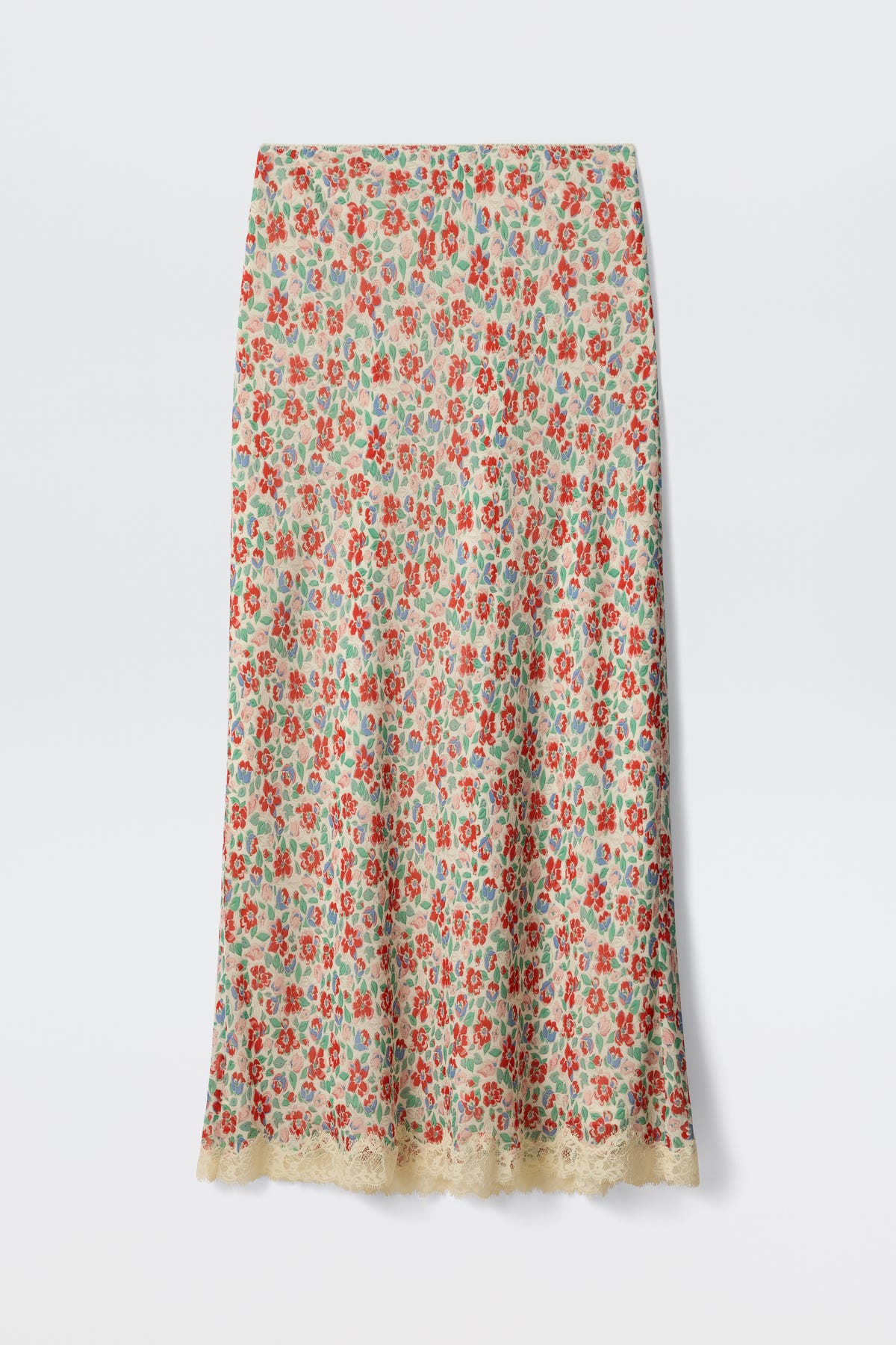 The Stassie - Jeannie Bloom Ivory is a long, straight skirt featuring a colorful red, green, and blue floral pattern on an ivory base with delicate beige lace trim along the hem.