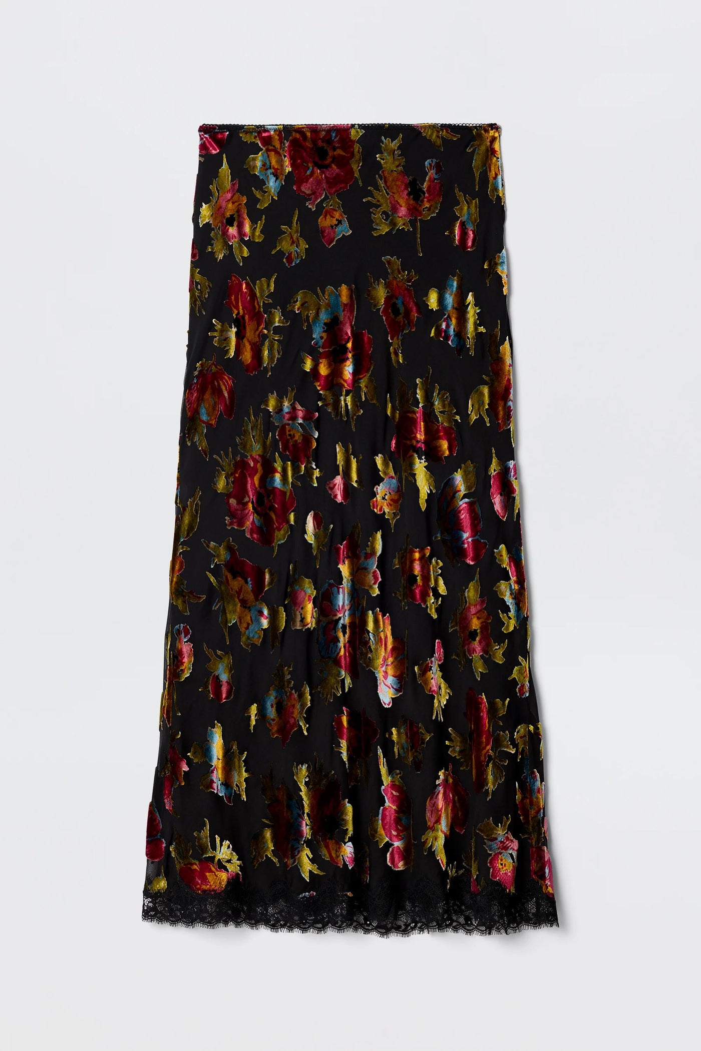 The Stassie - Countryside Devoré Black is a black midi skirt with red, gold, and purple floral patterns and a lace-trimmed hem, shown flat on a plain white background.