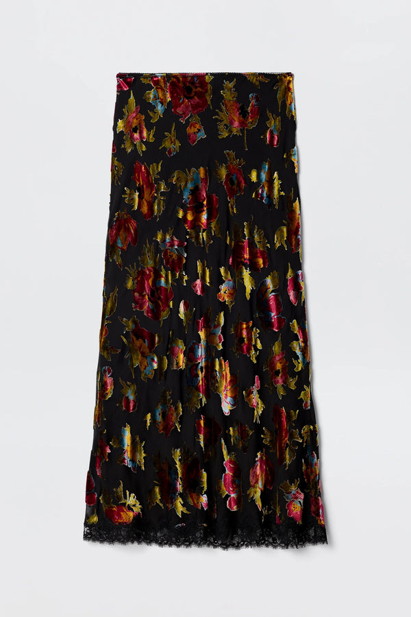 The Stassie - Countryside Devoré Black is a black midi skirt with red, gold, and purple floral patterns and a lace-trimmed hem, shown flat on a plain white background.