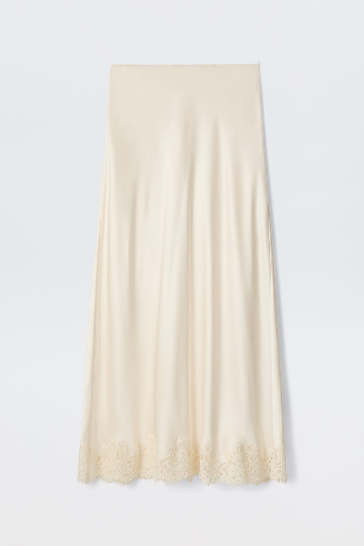 The Matilde - Pearl is a cream-colored satin slip skirt featuring delicate lace trim along the hem, ideal for a bridal look, shown against a plain white background.