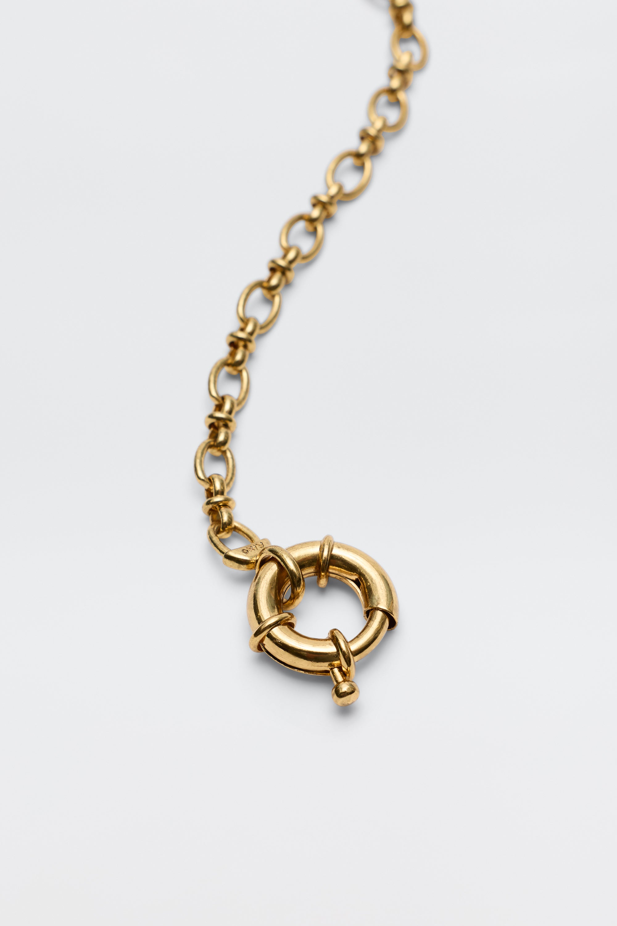 A close-up of the Lorene - Gold necklace, highlighting its large circular spring ring clasp—ideal for adding charms and customizing your own look—centered on a plain white background.