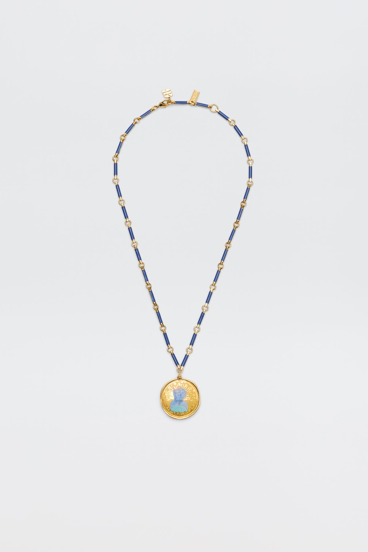 The Ari - Astro Gemini necklace features alternating blue and gold rectangular beads and a large round disc charm with a blue woman's profile at the center, shown against a plain white background.