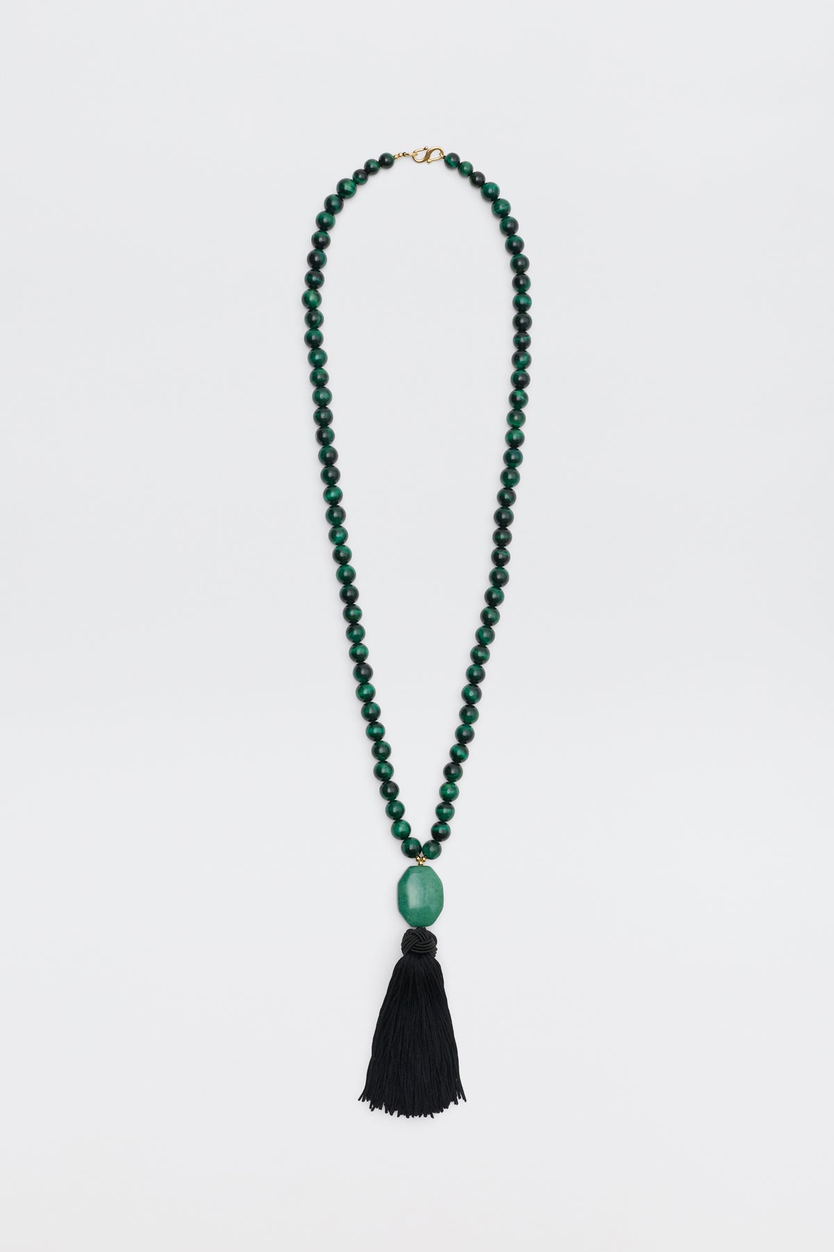 Cally - Green is a necklace featuring small round green beads, a large oval green bead at the center, and a long black tassel hanging at the bottom, displayed on a white background.