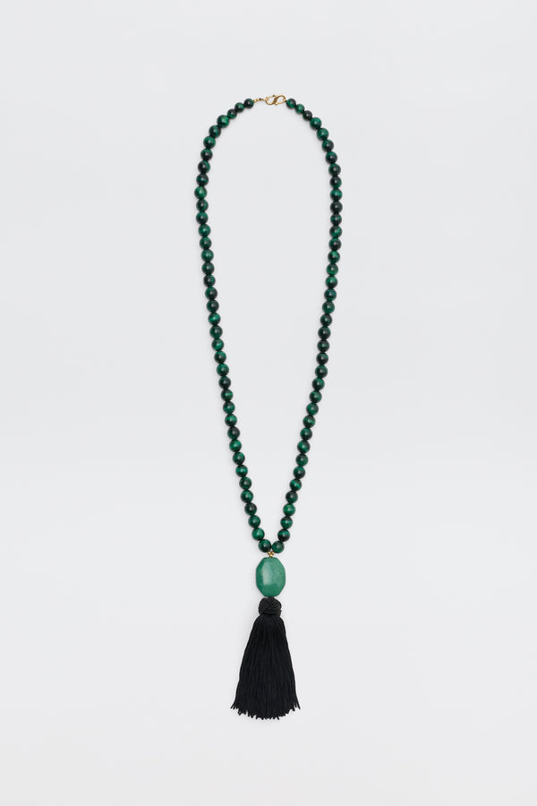 Cally - Green is a necklace featuring small round green beads, a large oval green bead at the center, and a long black tassel hanging at the bottom, displayed on a white background.