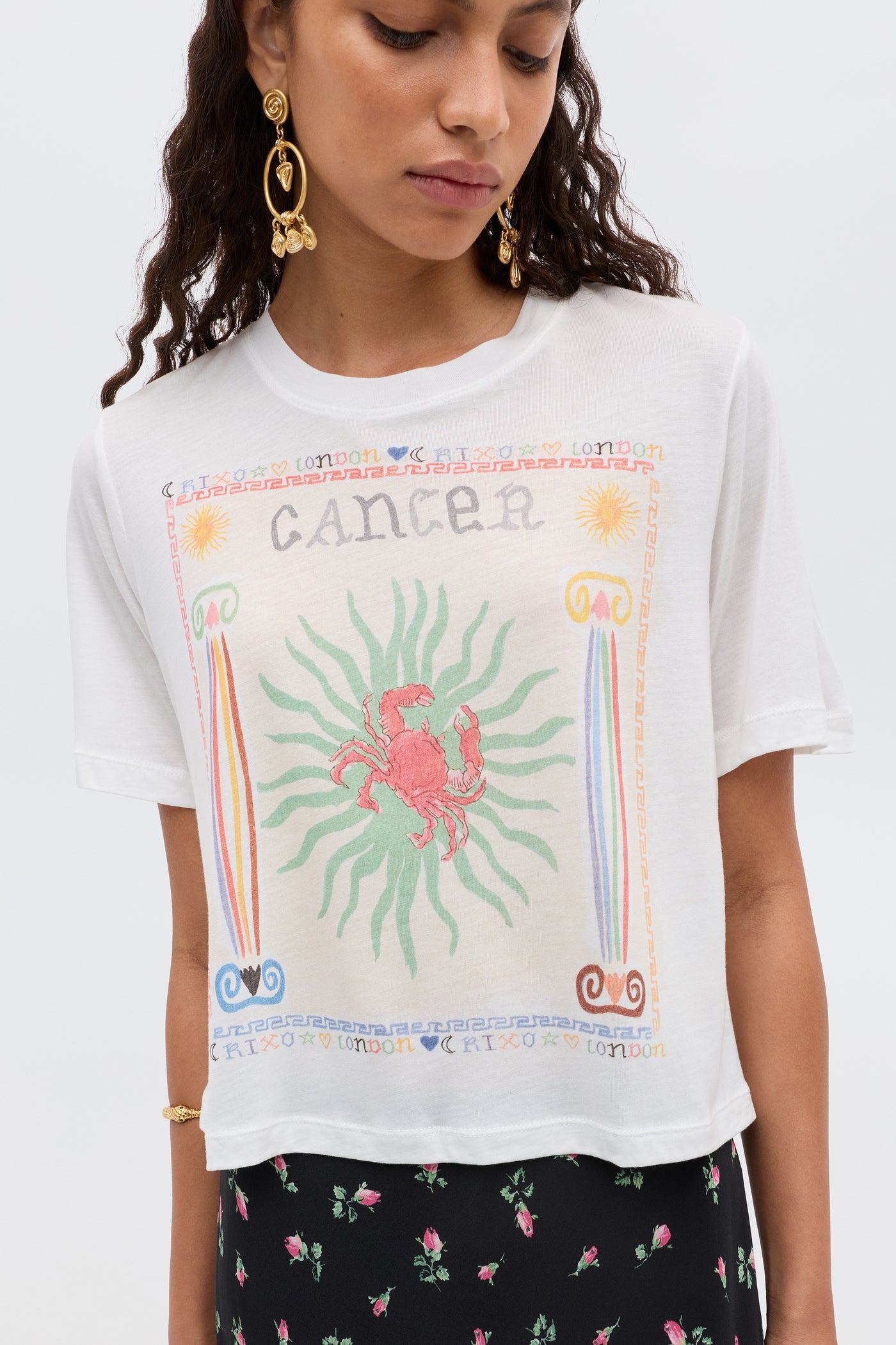 A woman wearing the Ria - Cancer T-shirt featuring a bold Cancer illustration.