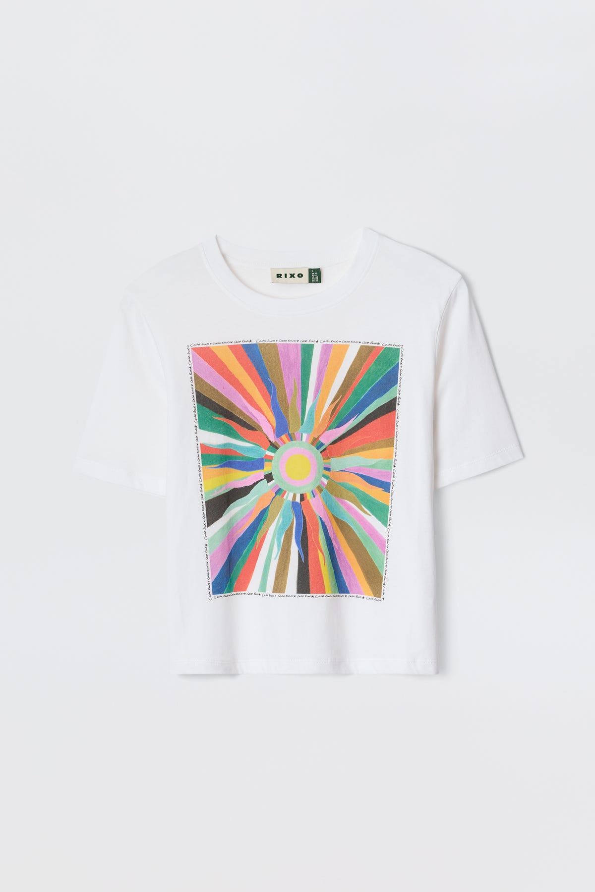 The Ria-Casa Soleil Multi T-shirt features a white base with a vibrant, abstract sunburst design and radiating colorful lines on the front, finished with a trendy cropped hem.