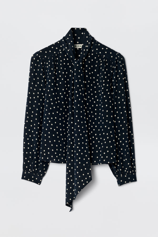 The Melaina - Layla Dot Navy is a stylish navy shirt with a chic scarf neckline, perfect for elevating any look.