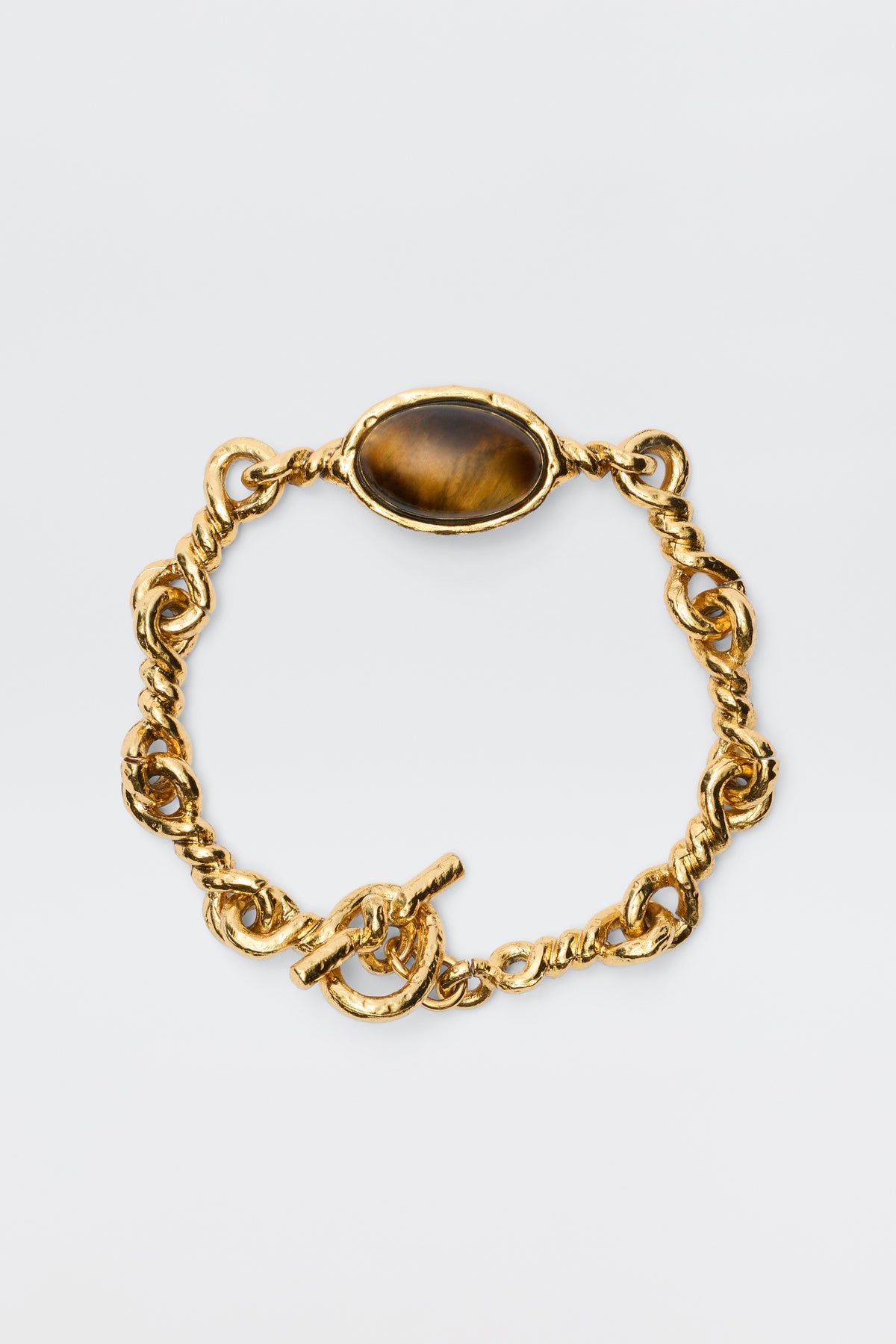 The Maelis - Gold is a vintage-inspired bracelet with chunky gold-plated twisted links and a central oval brown gemstone, displayed on a plain white background.