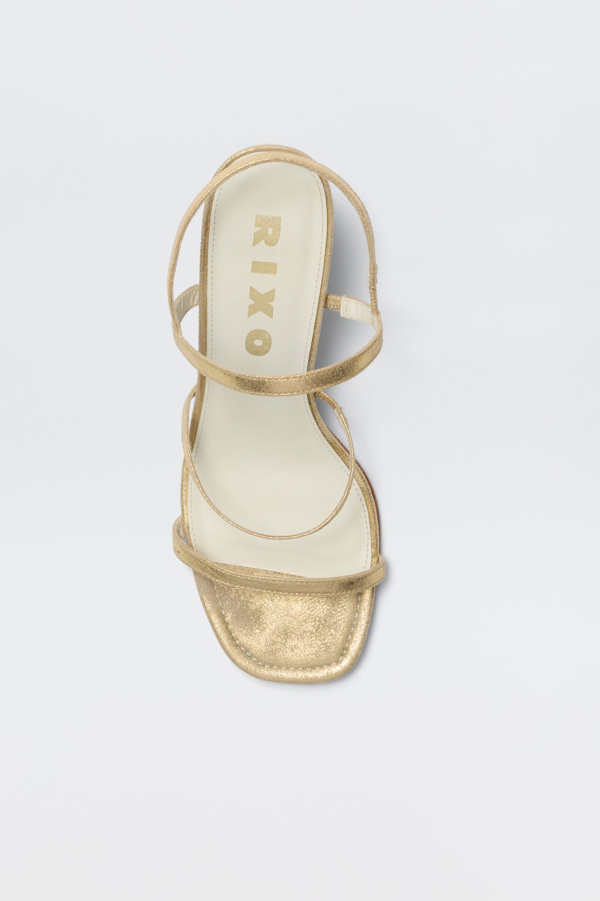 The Ciervo - Gold is a comfortable strappy sandal with a square toe and cream insole, featuring RIXO in gold on the footbed—the perfect match for elevating your RIXO occasion wear, shown against a white background.