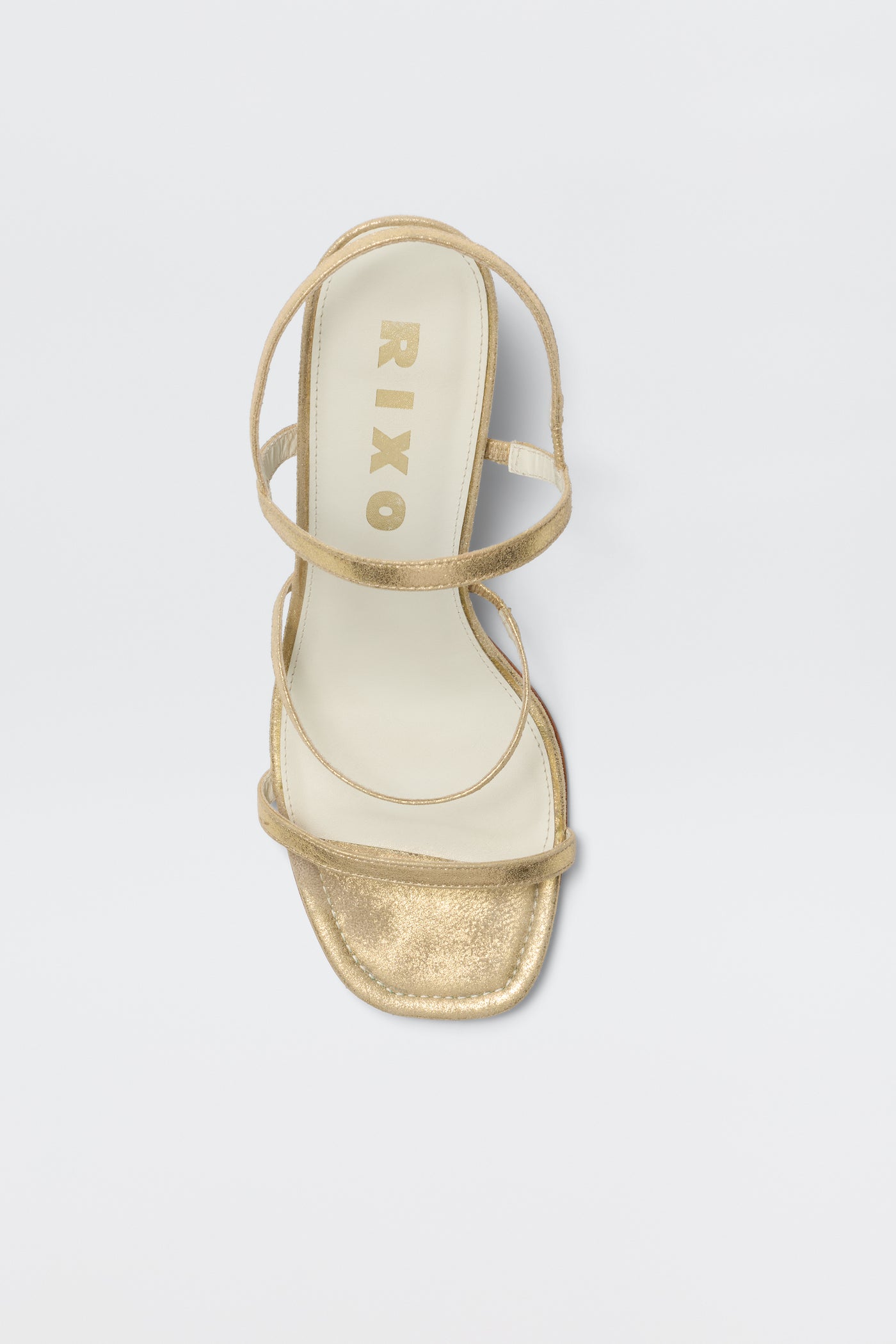 The Ciervo - Gold is a comfortable strappy sandal with a square toe and cream insole, featuring RIXO in gold on the footbed—the perfect match for elevating your RIXO occasion wear, shown against a white background.