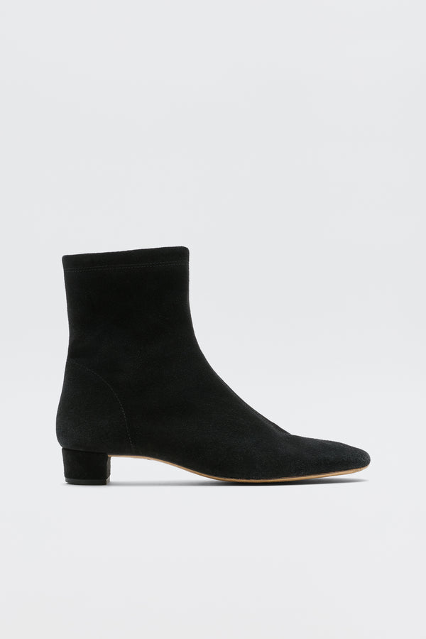 Rey - Black: An ankle-high suede boot in black with a rounded toe and low feminine heel, shown against a white background.