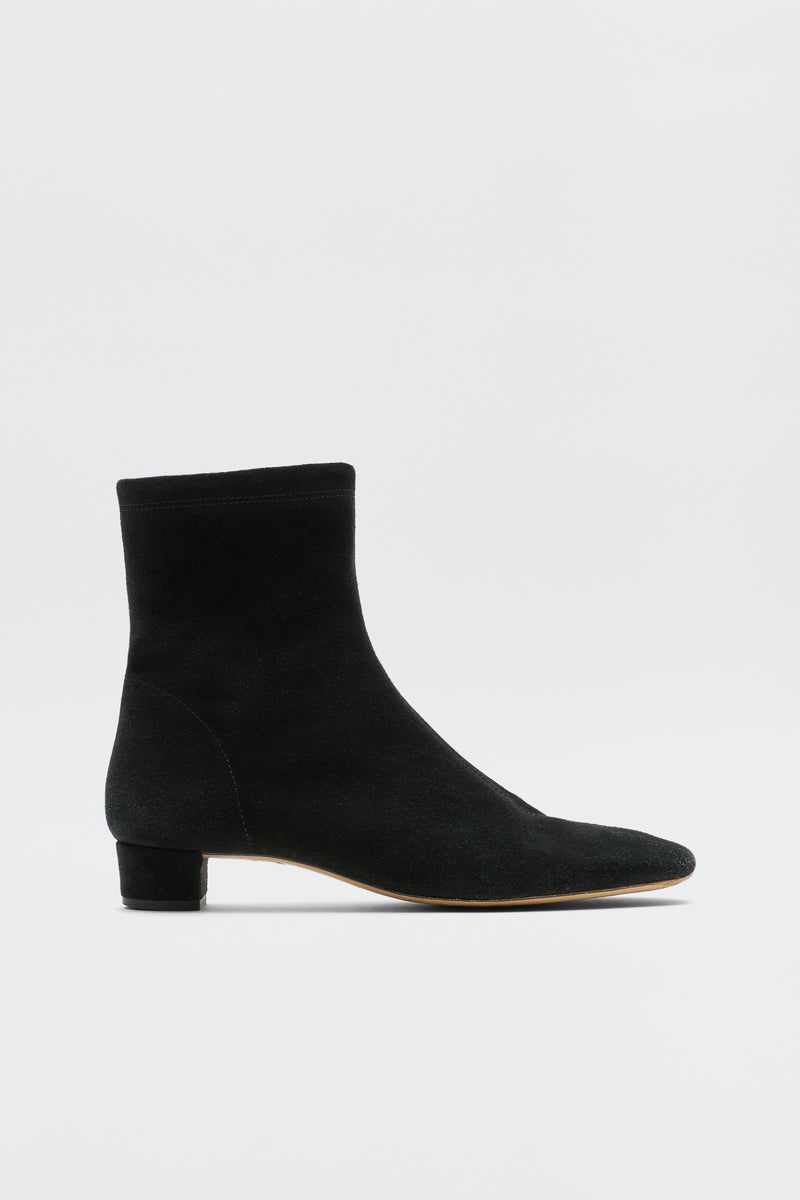 Rey - Black: An ankle-high suede boot in black with a rounded toe and low feminine heel, shown against a white background.