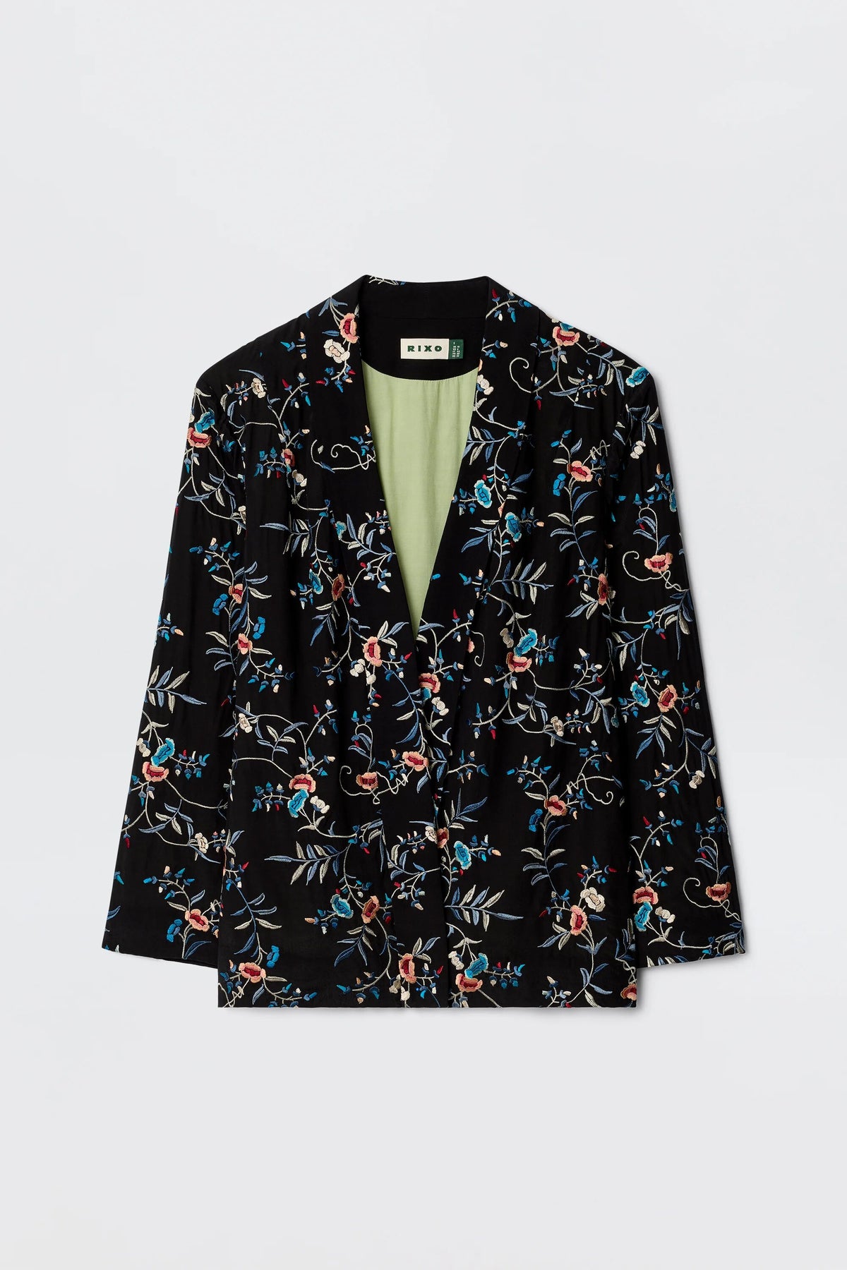 The Malachy - Botanical Embroidery Black is a black blazer with red, blue, and white embroidered botanical motifs, a light green lining, made from lightweight crepe. Shown on a plain white background.
