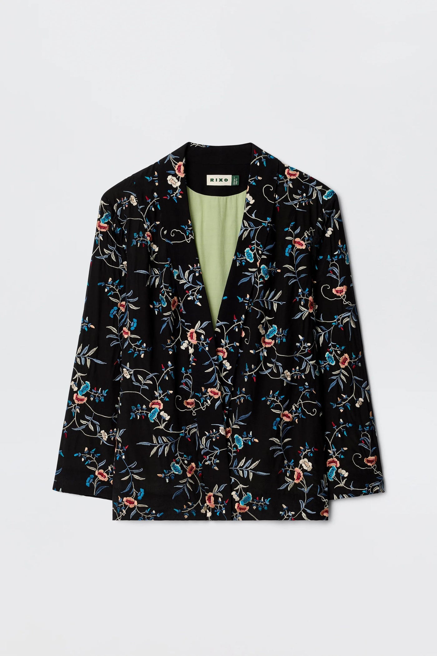 The Malachy - Botanical Embroidery Black is a black blazer with red, blue, and white embroidered botanical motifs, a light green lining, made from lightweight crepe. Shown on a plain white background.
