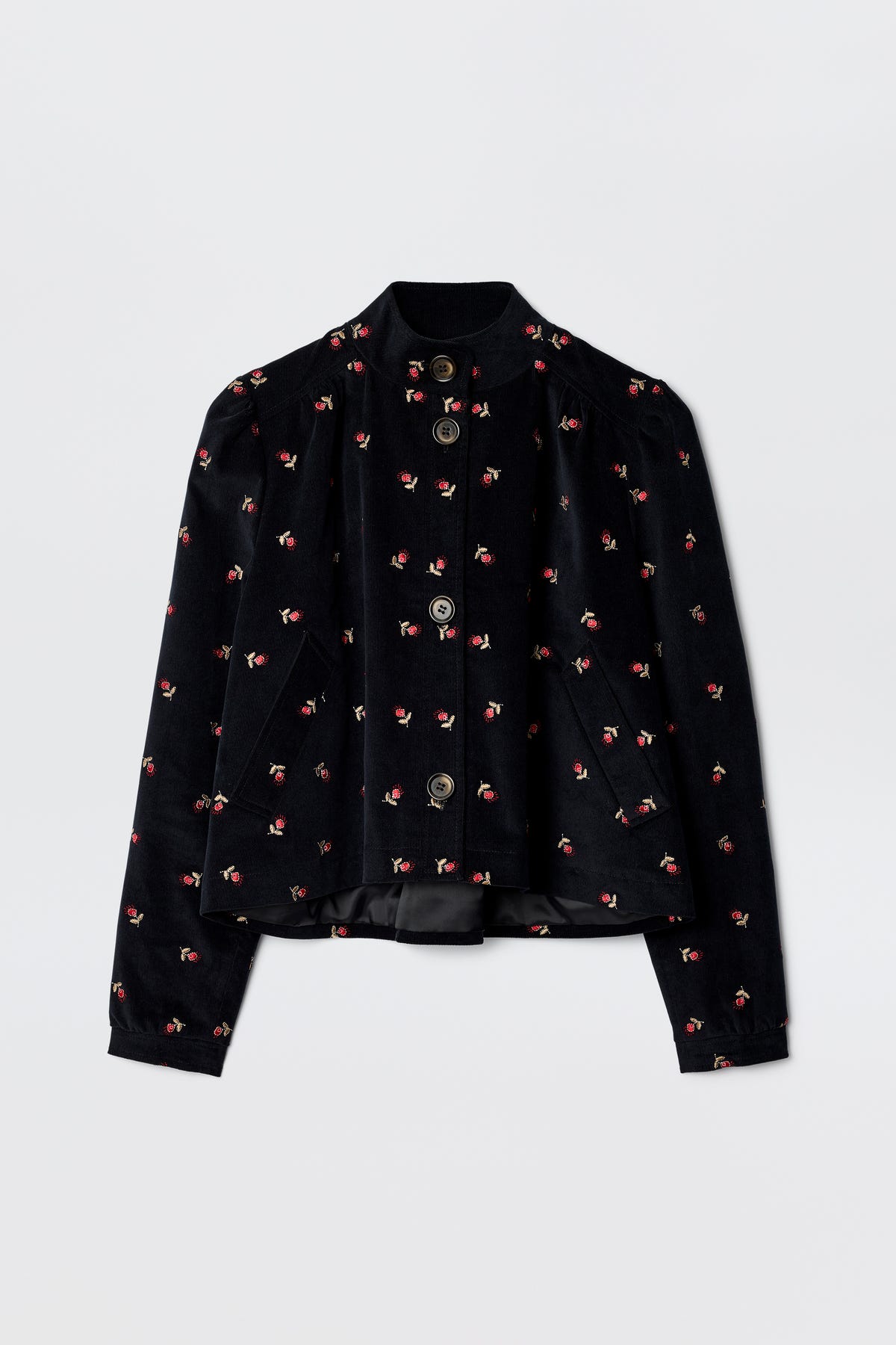 The Nyla - Dandy Embroidery Deep Navy is a 60s-inspired black velvet jacket with long sleeves, a mandarin collar, silver front buttons, and scattered pink and red floral embroidery.