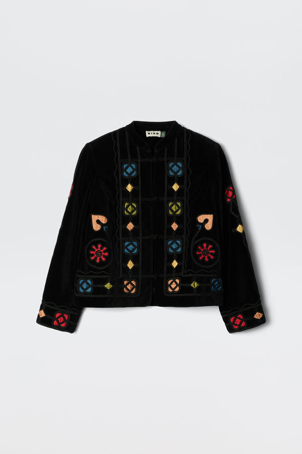 The Viktoria - Serino Applique Black jacket features black velvet and colorful embroidered geometric and floral patterns in red, blue, yellow, and beige, displayed on a plain white background.