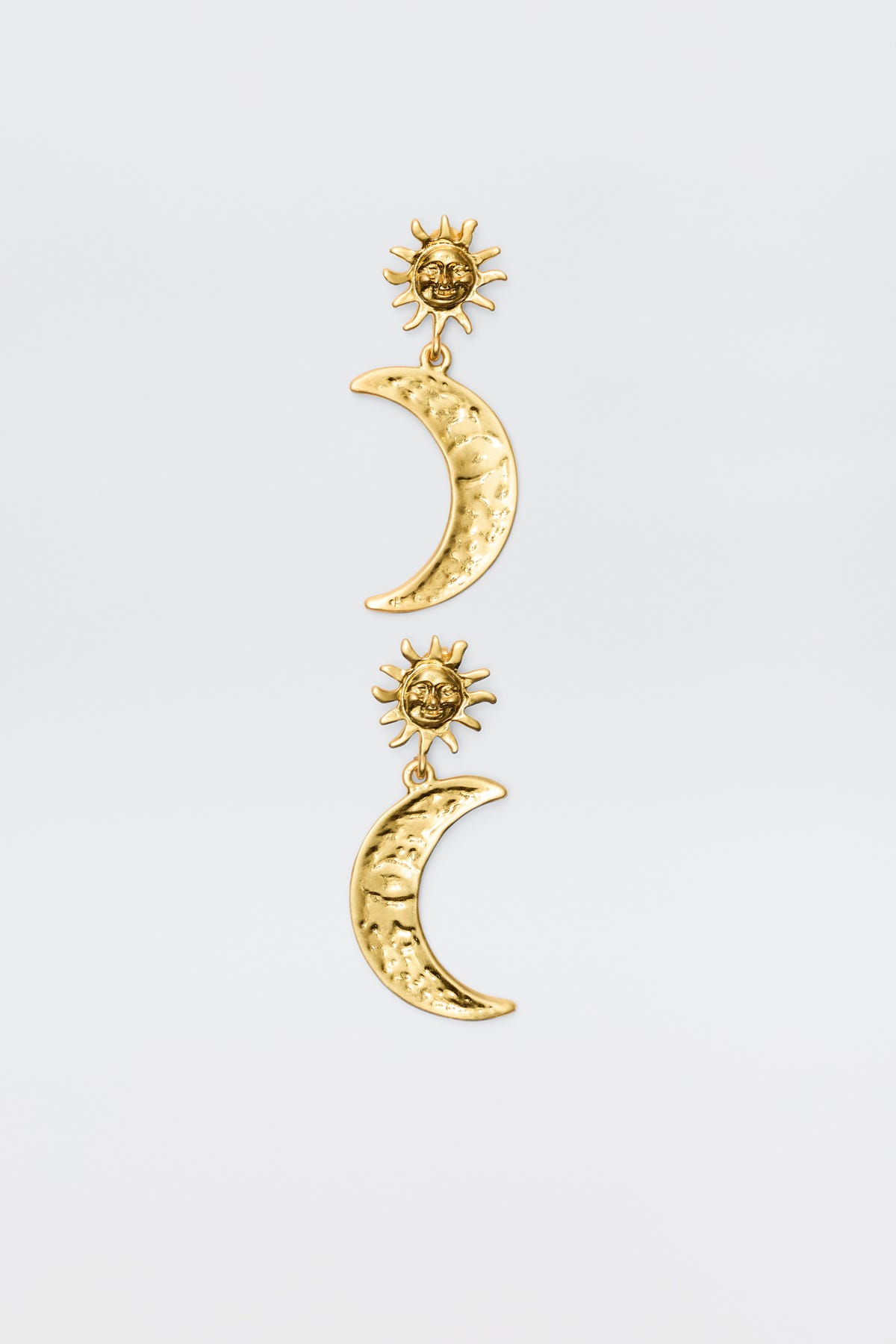 The Davies - Gold earrings feature gold-plated celestial charms: a textured crescent moon hangs from a detailed sun, creating a vintage-inspired look against a plain white background.