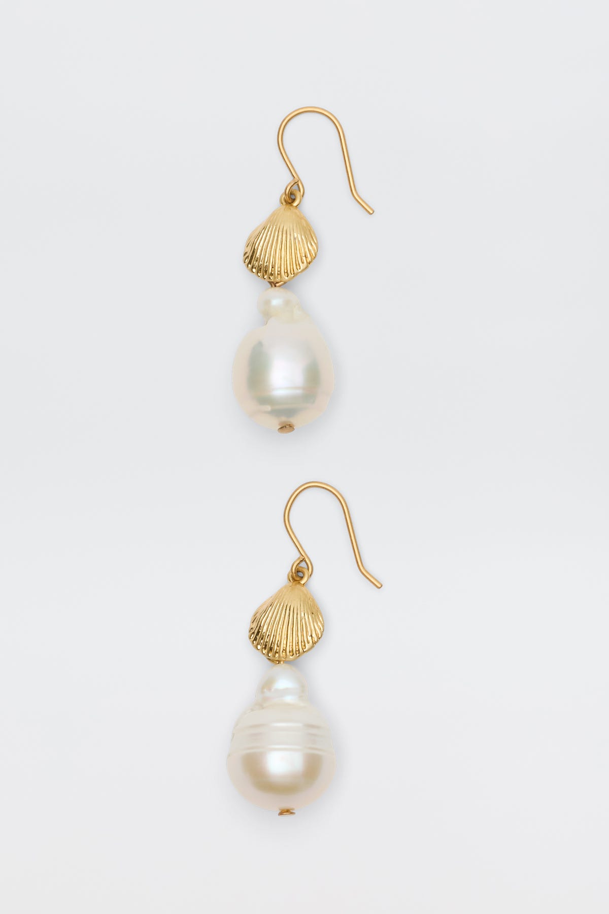 Rosaria - Gold earrings feature a gold-plated design with a seashell-shaped accent and a large resin pearl, creating an elegant look. Shown on a plain white background.