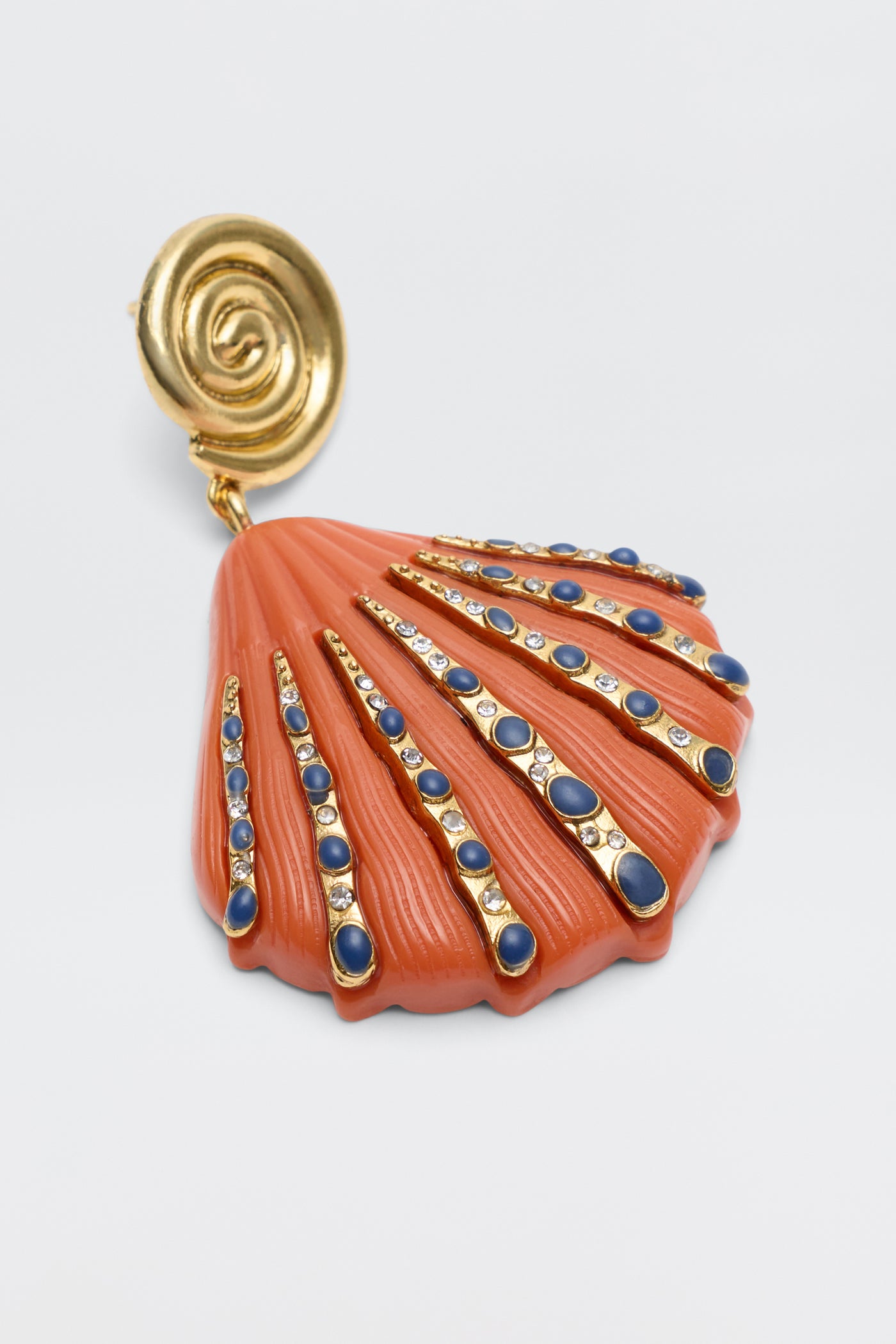 The Daphne - Orange is a vintage-inspired shell-shaped earring encrusted with orange and clear gemstones set in gold lines radiating from the center, finished with a circular gold clip.