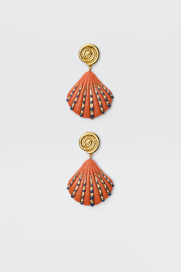Daphne - Orange earrings feature gold spiral studs with orange-red shell-shaped pendants accented by blue, gold, and black beads, shown on a white background.