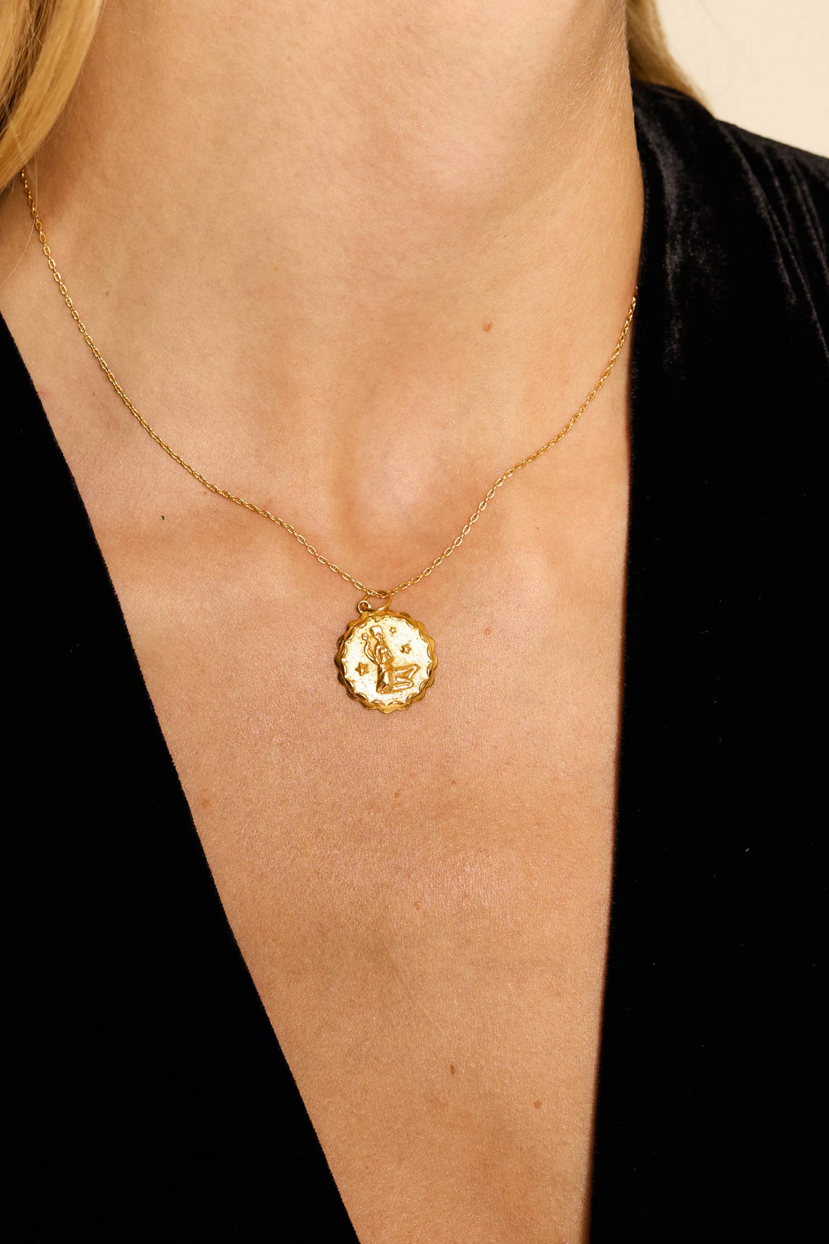 A close-up of a woman's neck adorned with the Zodiac - Virgo necklace, worn over a black V-neck top.
