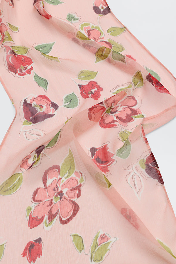 Julien - Kimmie Floral Pink is a light pink sheer fabric with red and pink floral patterns and green leaves, draped in soft folds on a white background.
