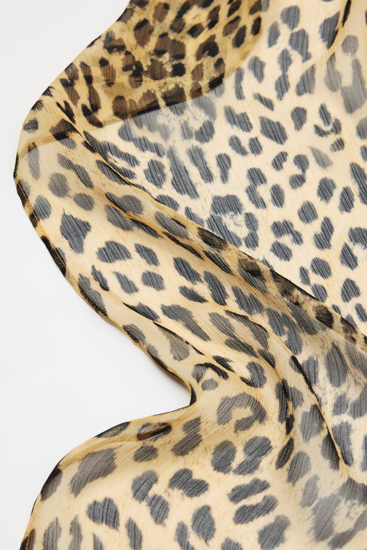 A close-up of Julien - Nina Leopard Brown, a sheer, lightweight fabric with a beige, brown, and black leopard print draped softly against a white background.