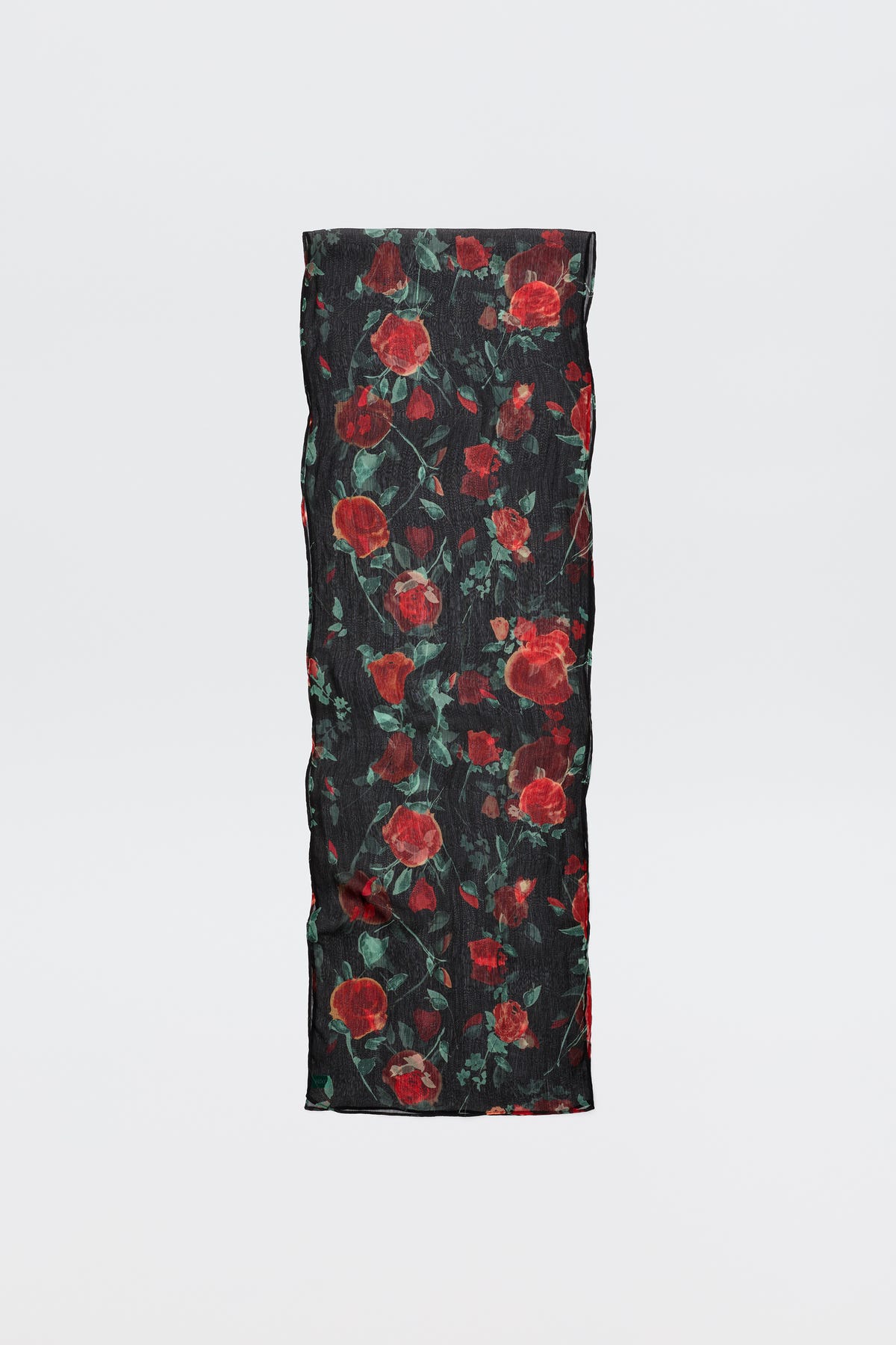 The Julien - Claudia Rose Black is a long, rectangular black scarf featuring red rose patterns with green leaves, displayed against a plain light background.