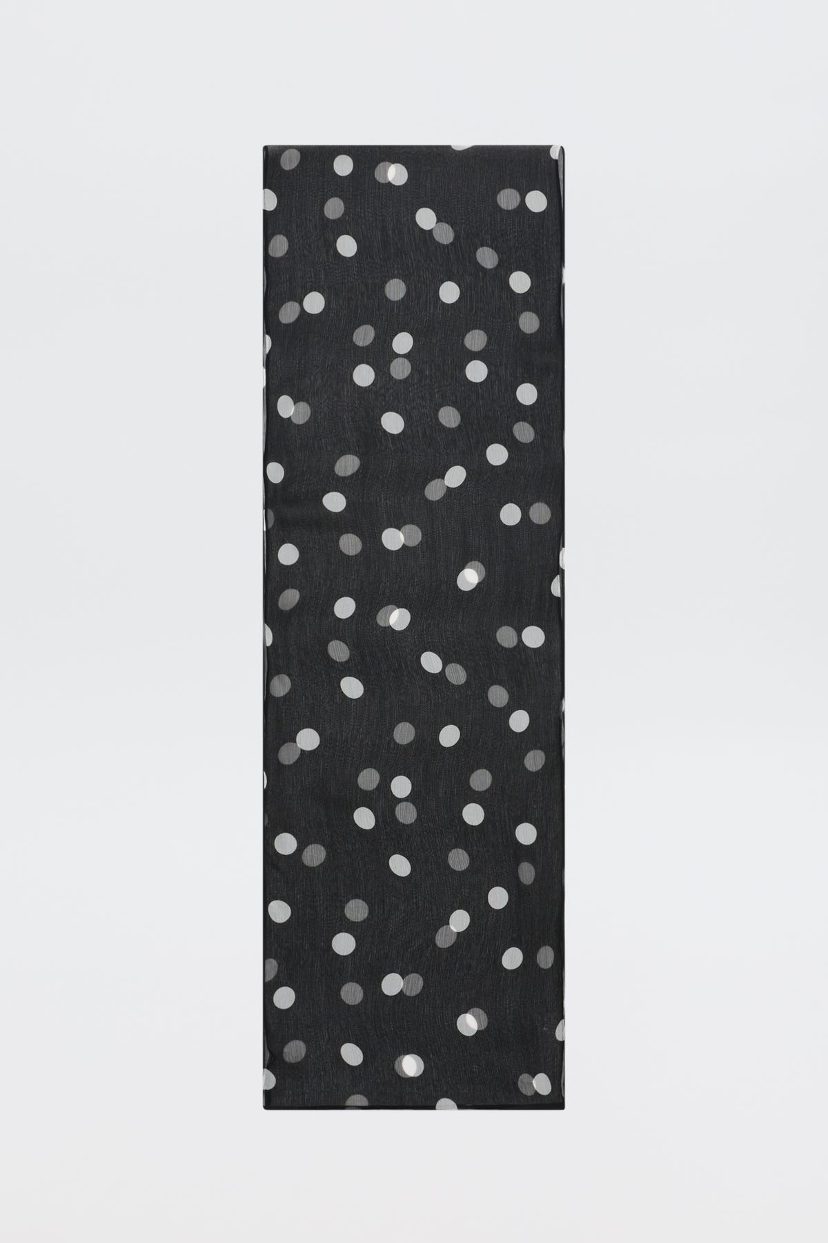 A tall, rectangular object named “Julien - Cosmos Spot Black,” featuring a pattern of scattered white polka dots on its black surface, is placed against a plain white background.