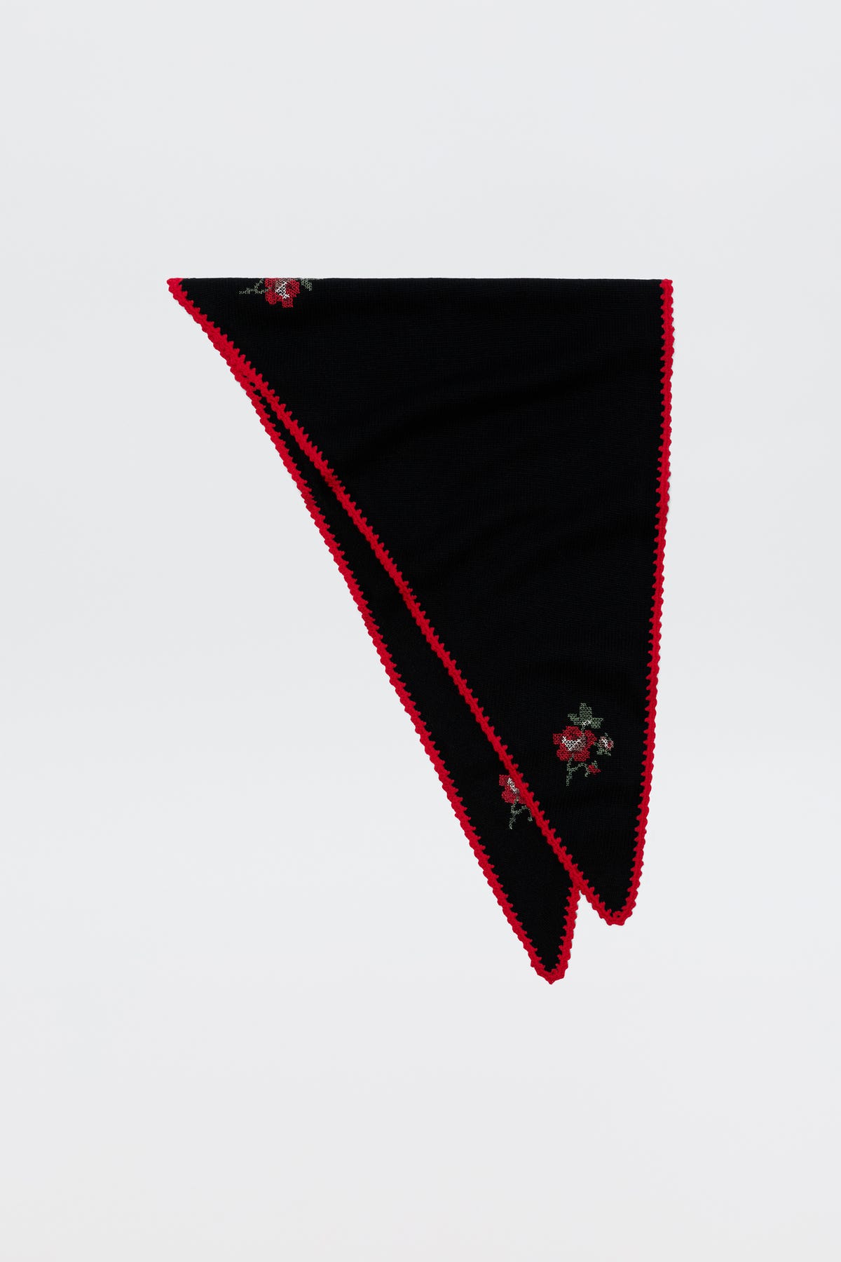 Sure! Here’s a rewritten sentence using your product data: The Lianora - Abi Rose Knit Black features a black triangular design accented with red trim and delicate embroidered red roses, shown folded neatly on a plain white background.