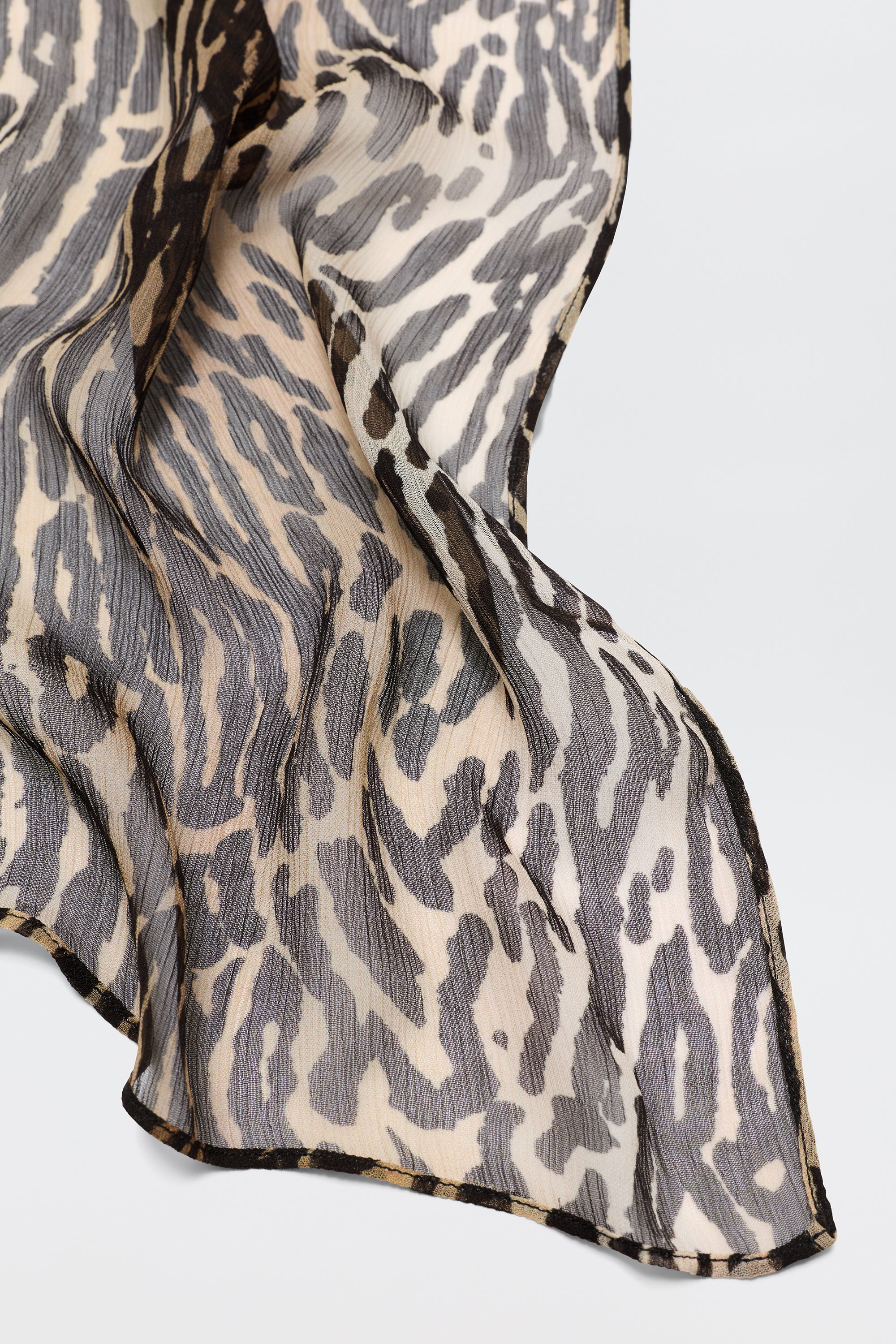 Julien - Bohemia Leopard is a sheer, lightweight fabric featuring a black, beige, and tan Bohemia Leopard print, elegantly draped—ideal for creating stylish printed dresses.