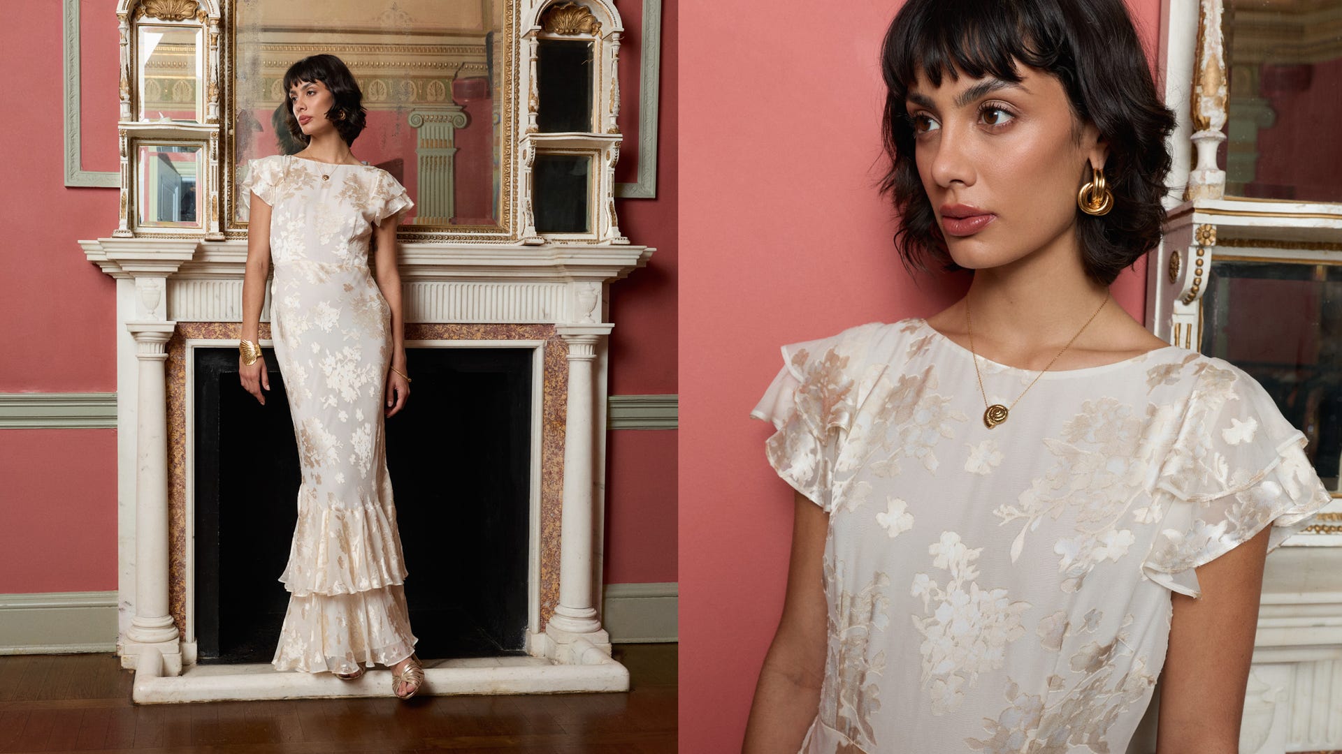 Woman in a white lace dress standing in a room with pink walls and a fireplace.