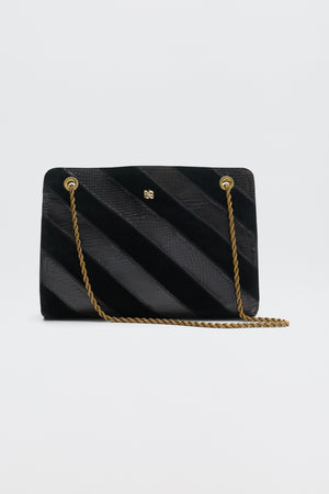 Eleina - Black handbag featuring alternating diagonal stripes of textured and smooth material, a gold chain shoulder strap, and a small gold logo.