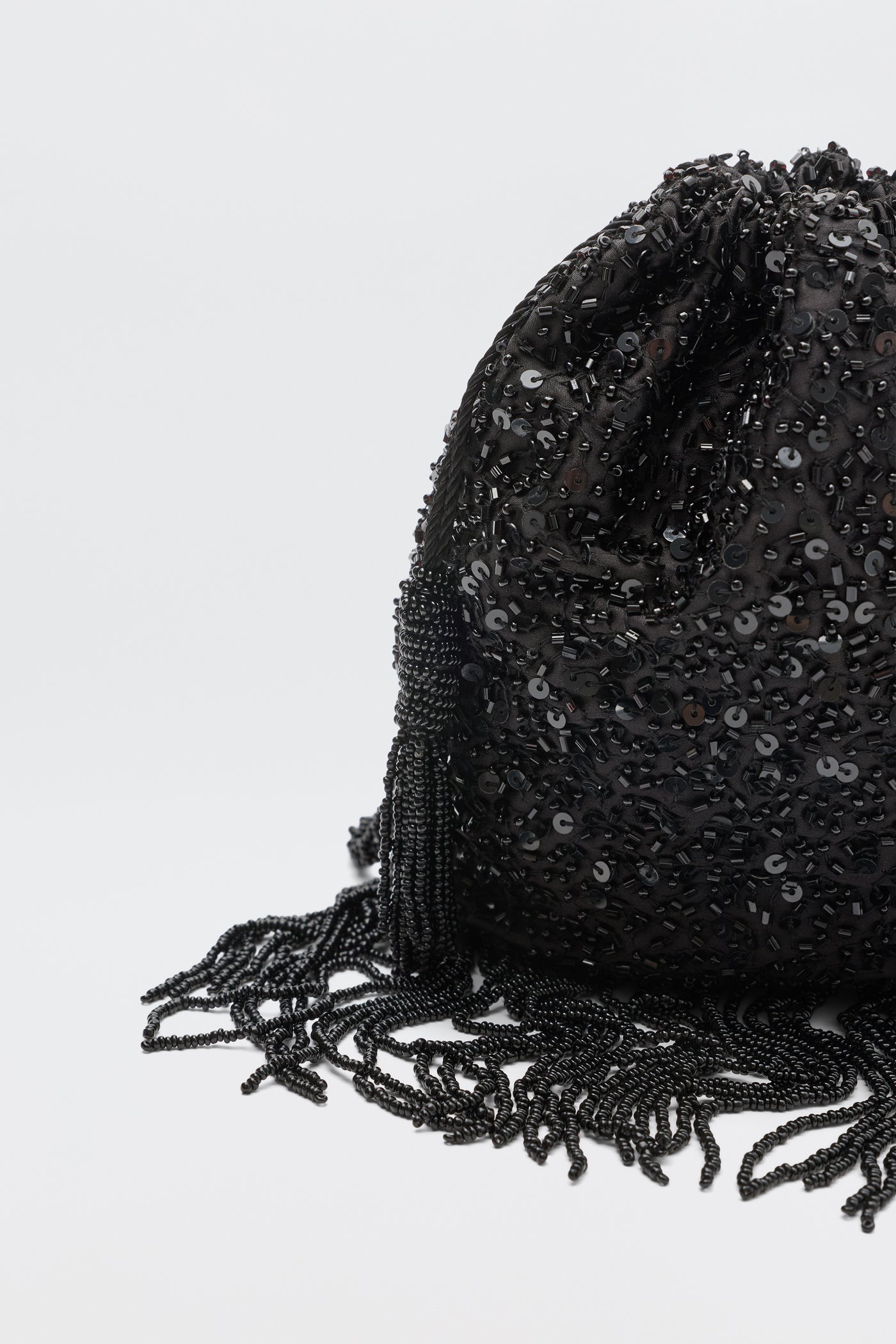 The Orla - Vintage Scatter Embellishment Black is a black sequined drawstring pouch with beaded tassels and fringe, shown on a plain white background.