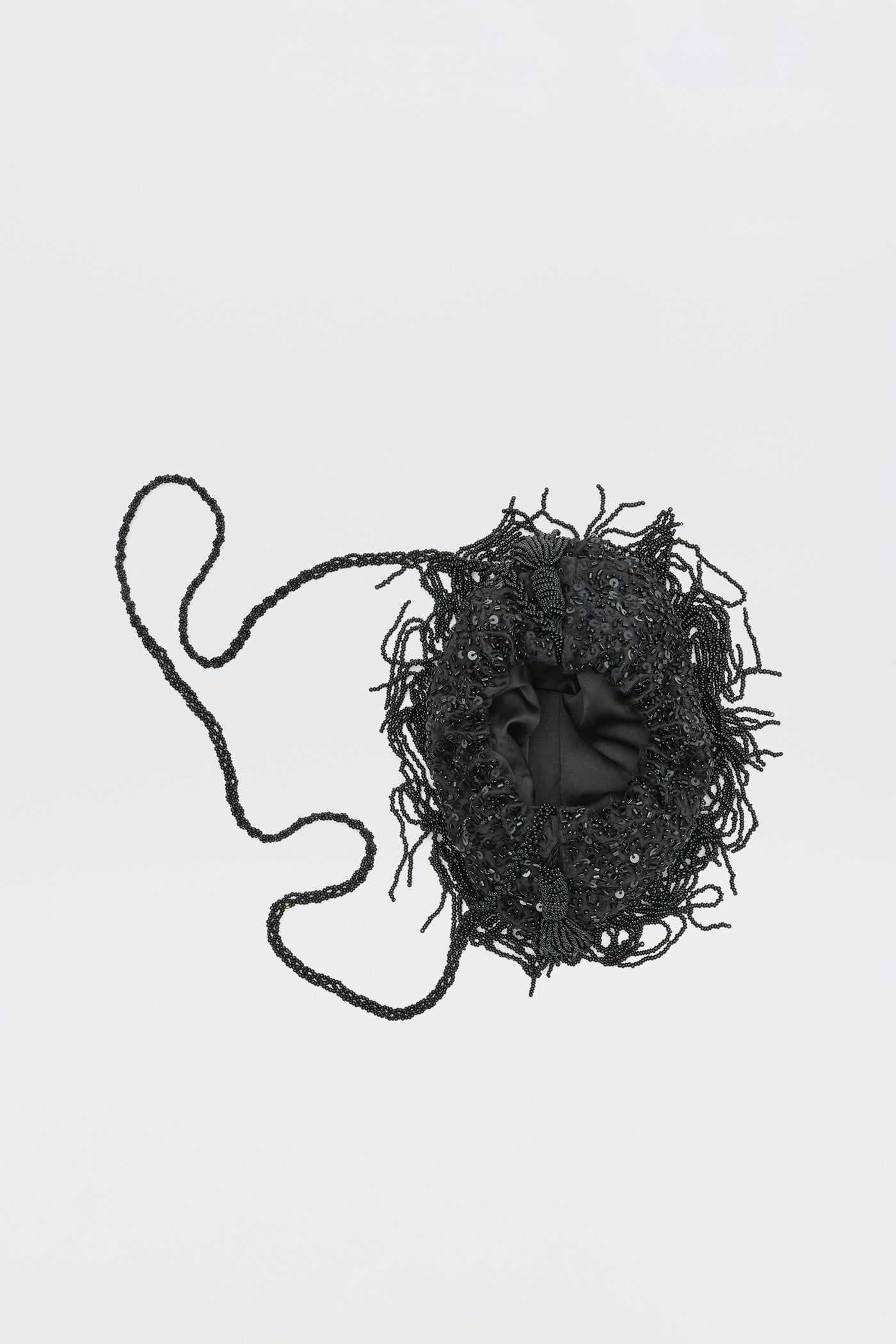 The Orla - Vintage Scatter Embellishment Black is a small, round black handbag with a beaded handle and decorative fringed beadwork, shown on a plain white background.