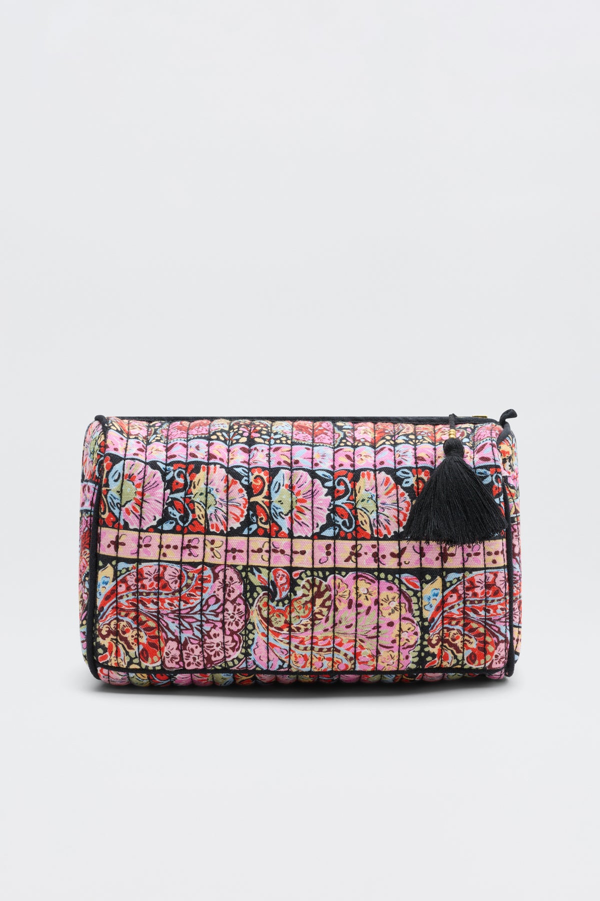 The Jadina - Cara Stripe Black is a rectangular clutch with a colorful floral and geometric quilted pattern in pink, red, and blue. It features a black zipper, a black tassel on the pull, and is shown against a plain light background.