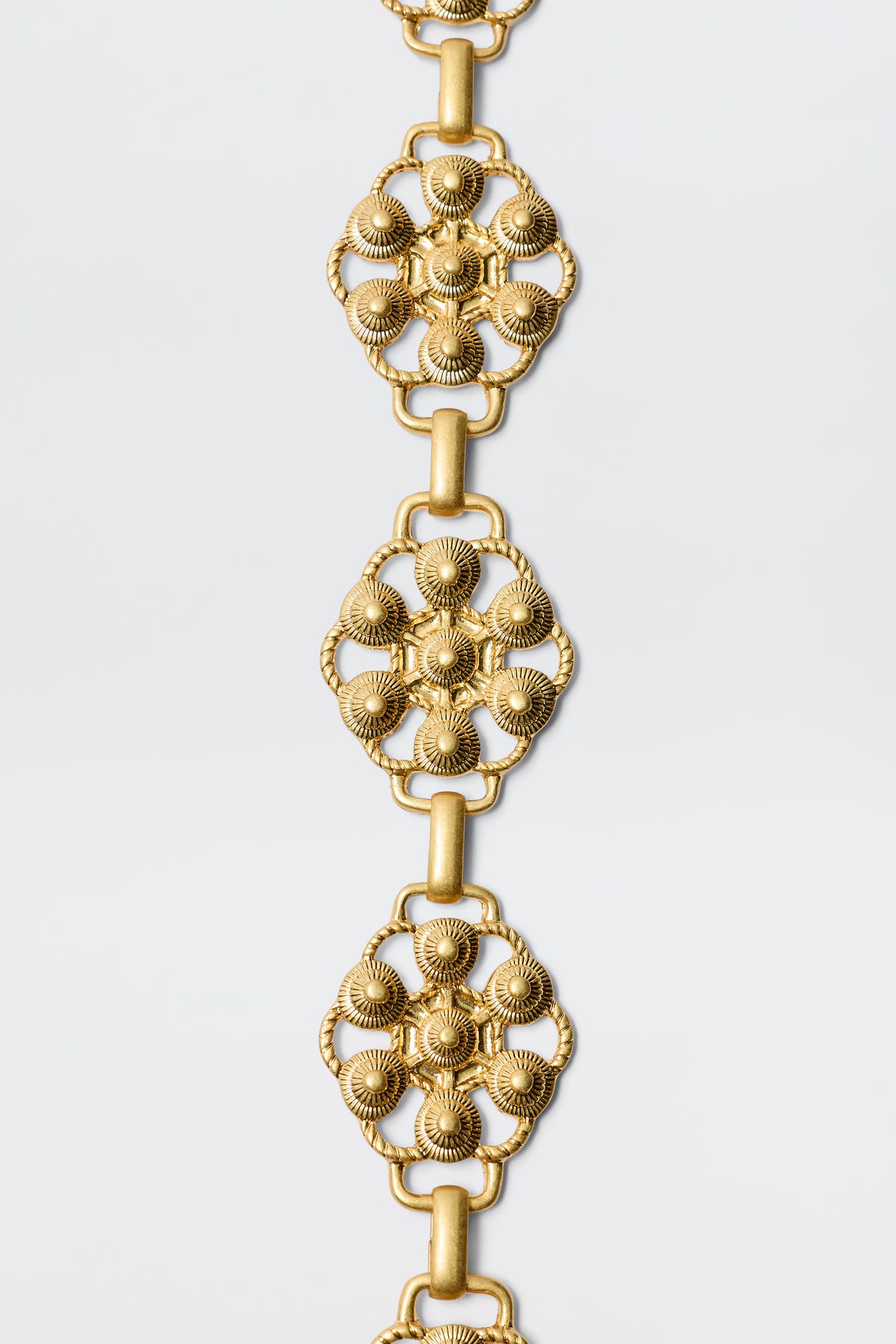 The Tiana - Gold bracelet features vintage-gold plating and a floral design inspired by RIXO’s signature daisy-chain belt.