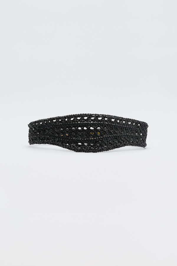 The Roxella - Black is a black crocheted headband with an open, airy pattern and a curved shape, shown against a plain white background—a stylish alternative to classic leather or woven belts for accessorizing.