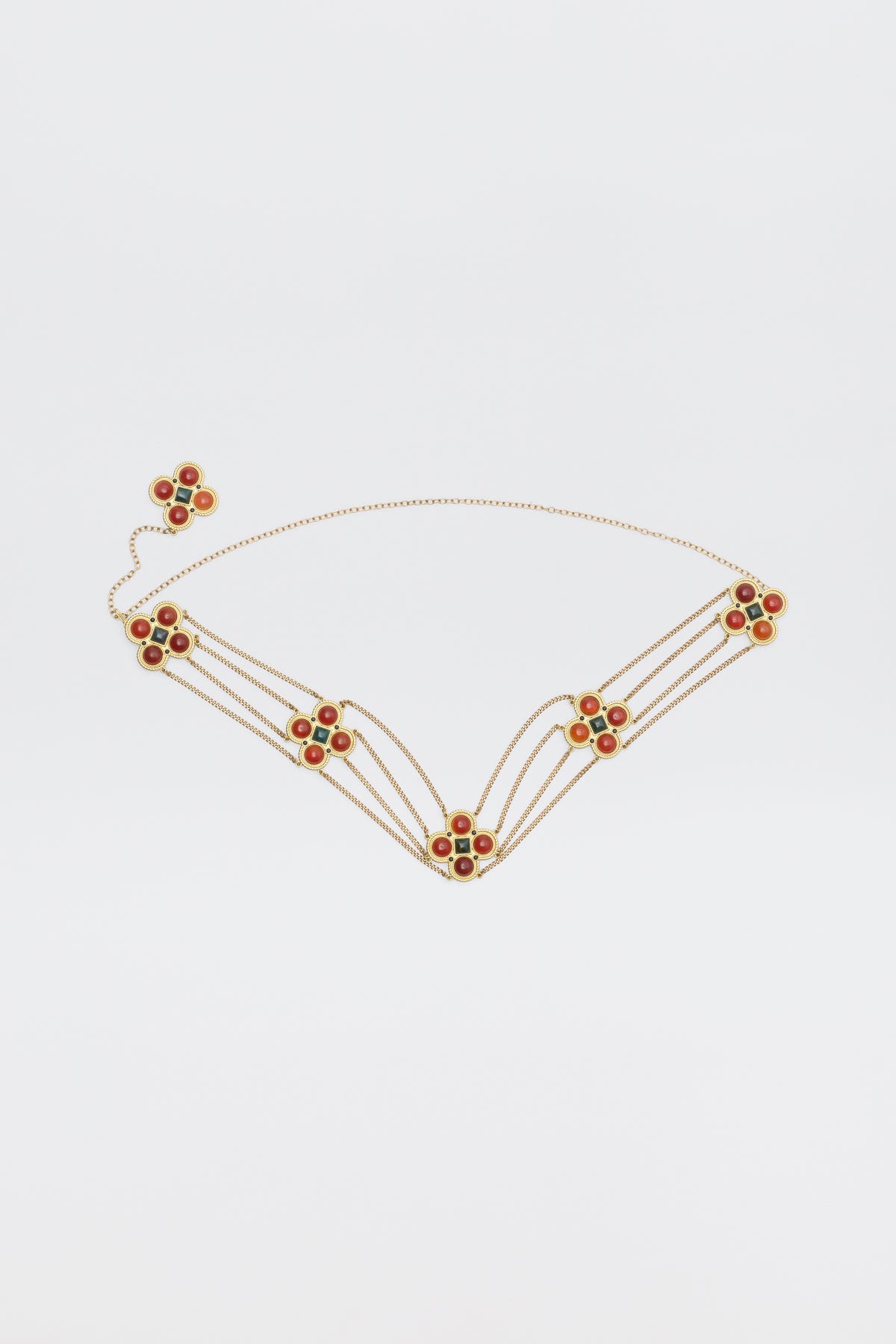 Noelia - Gold chain belt featuring five flower-shaped charms accented with orange and green stones.