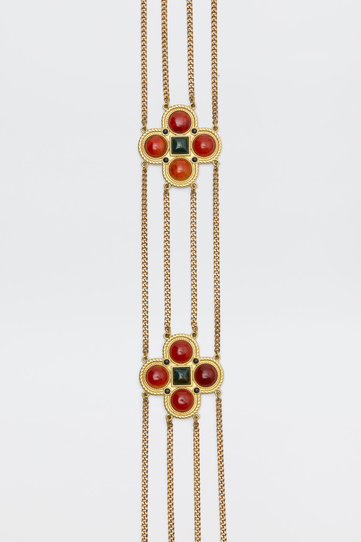The Noelia - Gold chain necklace features two square-shaped pendants with four red cabochons and a central dark green square inlay.