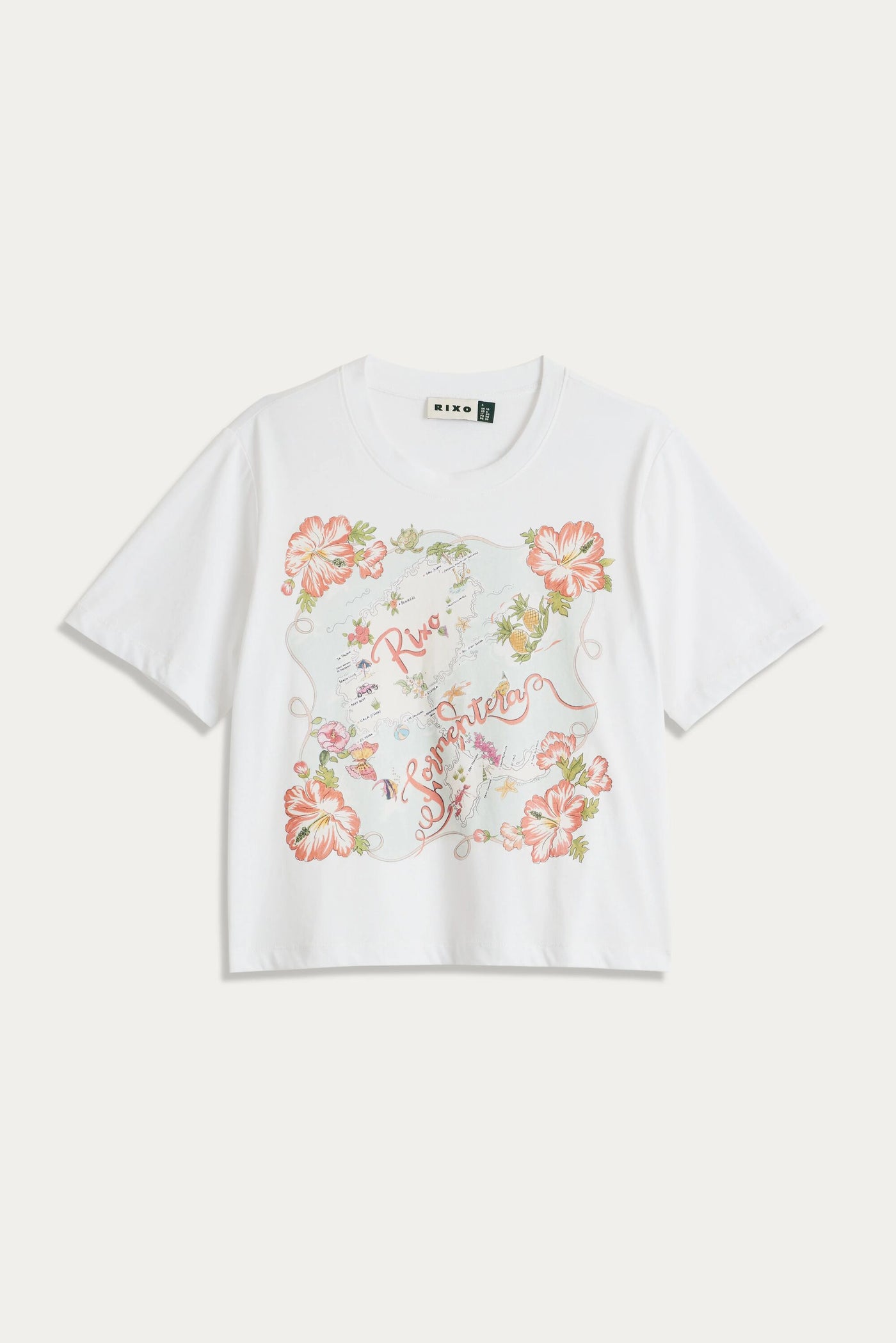 The Sabria - Ibiza Souvenir White short-sleeve T-shirt features a colorful floral design with red, pink, and green flowers, script text at the center, vintage poster-inspired accents, and decorative elements.