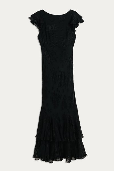 A long, elegant Ordinia - Bouquet Devoré Black gown with short flutter sleeves and a flared hem, shown on a plain light background. This 1930s-inspired dress features a subtle textured pattern and fitted silhouette. Perfect for black-tie weddings.